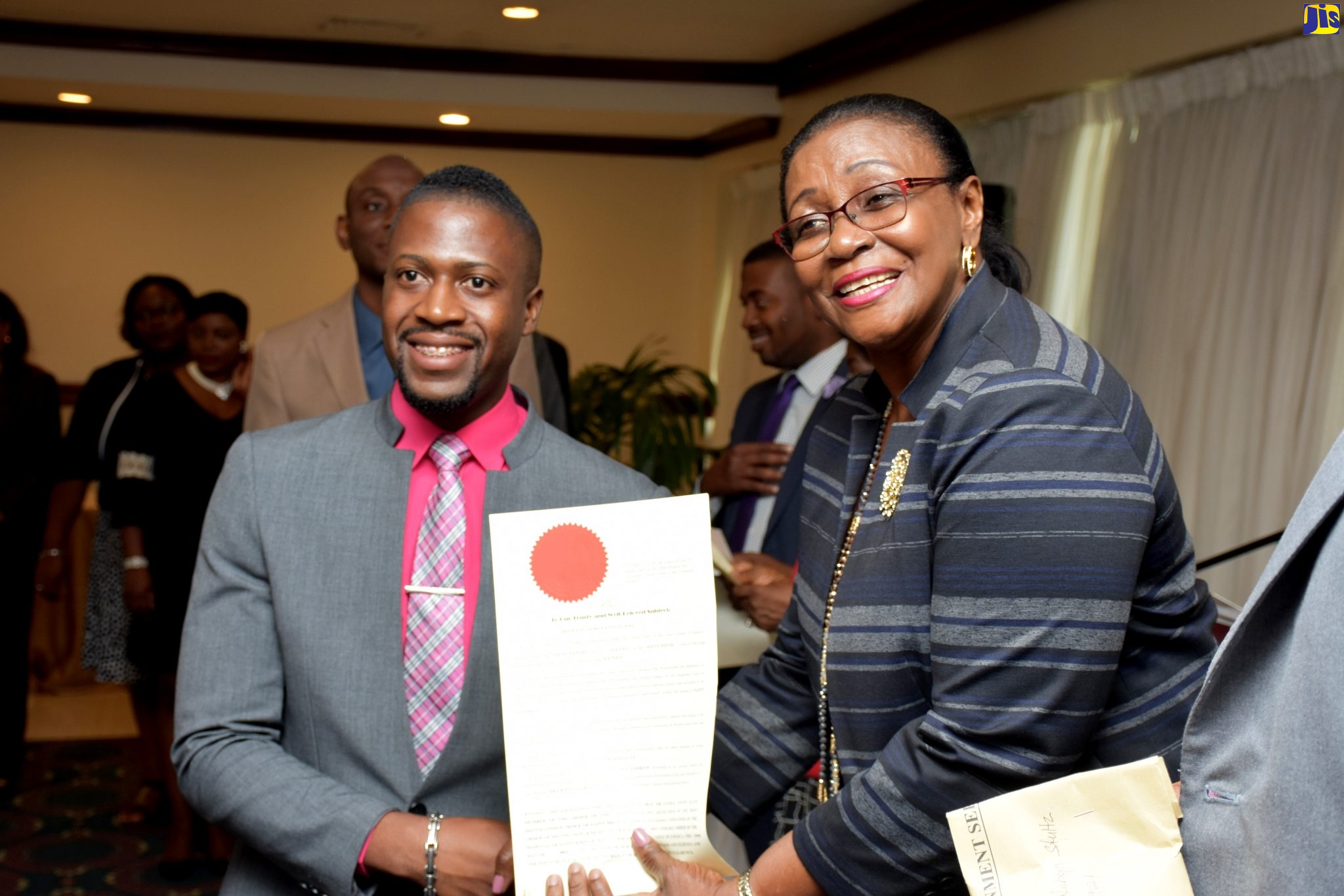 Custos Rotulorum for St. Andrew, Hon. Dr. Patricia Dunwell (right), presents a certificate to one of the youngest commissioned Justices of the Peace (JPs), Shawn Stultz, during a swearing-in ceremony for JPs for St. Andrew, at The Jamaica Pegasus hotel in New Kingston in 2018.