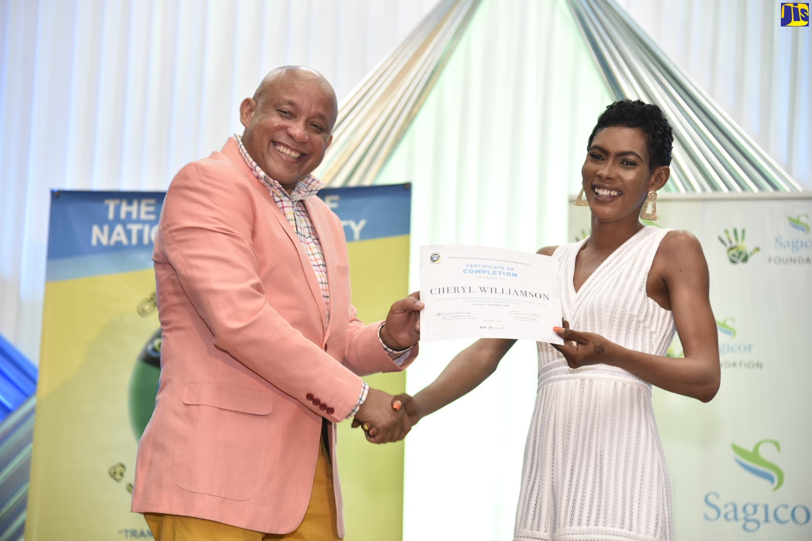 Executive Vice President, Sagicor Life Insurance, Mark Chisolm (left), presents a certificate to Citizen Security and Justice Programme (CSJP) III participant, Cheryl Williamson, at the graduation exercise for the adult literacy and social skills intervention programme on December 5, at the Sagicor Auditorium, St. Andrew. Thirty-three participants received training in academic and behaviour intervention, mentorship for job preparation as well as individual counselling sessions.