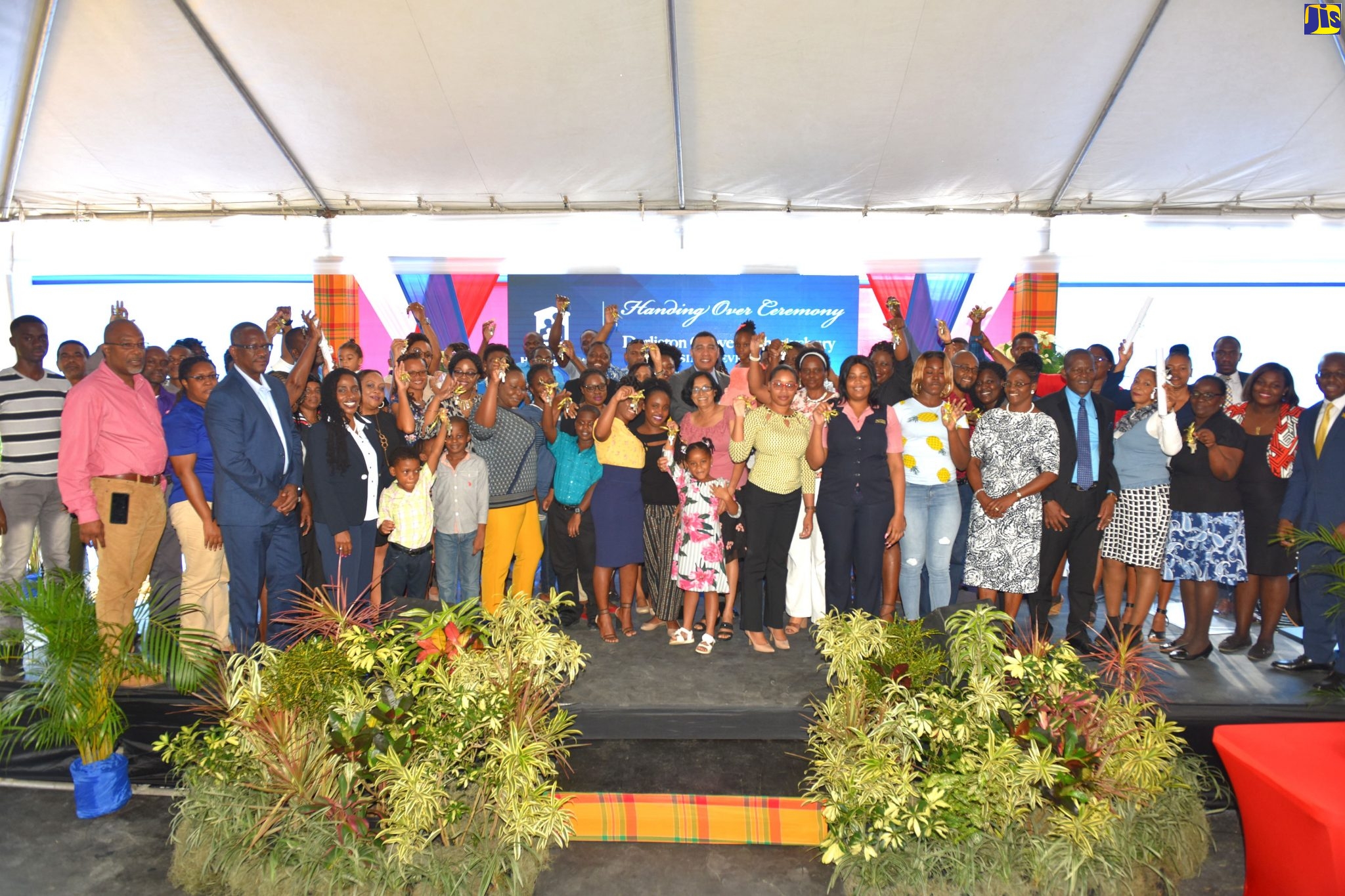 Prime Minister, the Most Hon. Andrew Holness (centre), is surrounded by new homeowners of the Darliston Grove and Shrewsbury communities in Westmoreland, at the National Housing Trust (NHT) handover ceremony, on Wednesday, December 4.