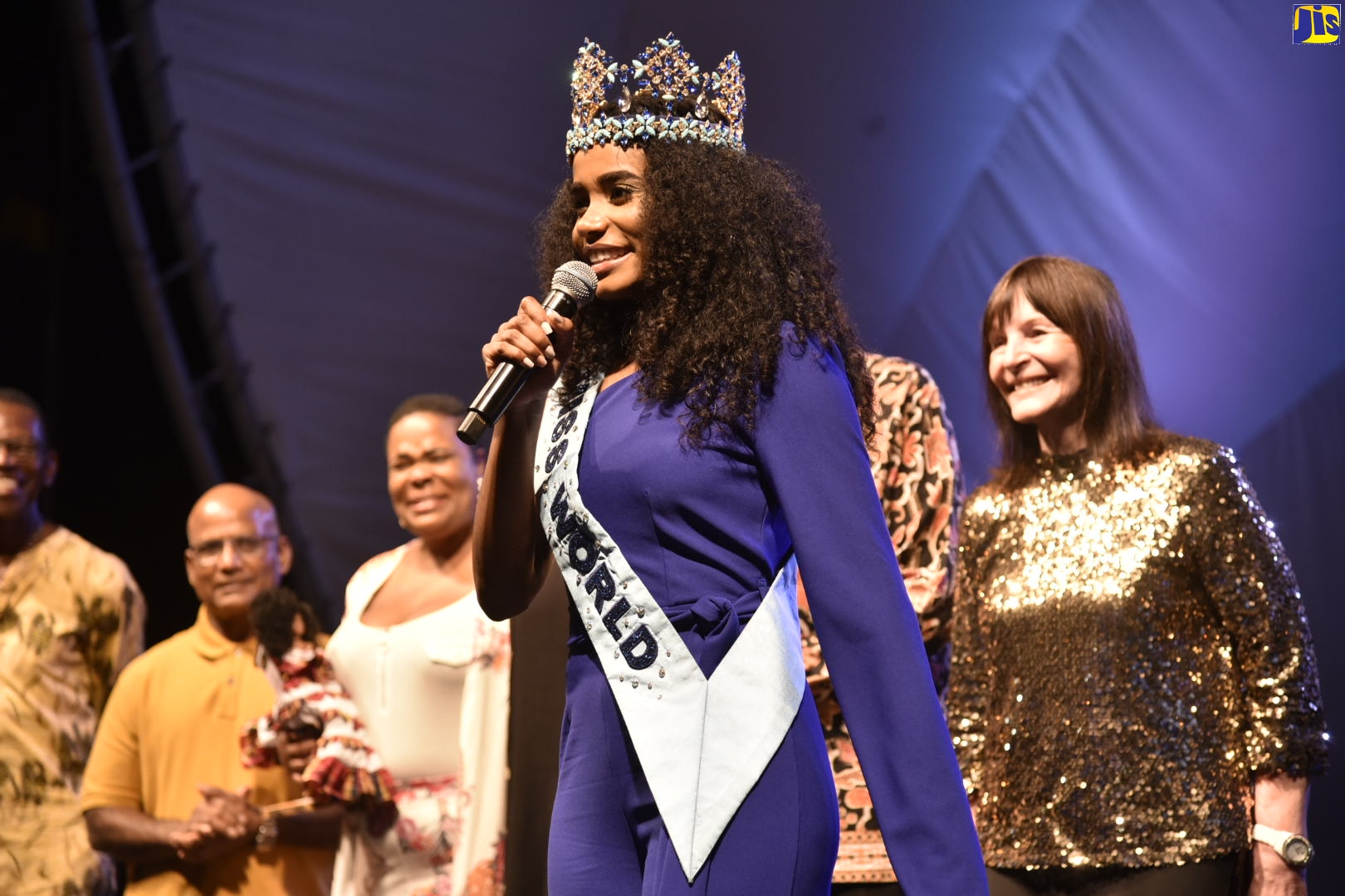 Miss World 2019, Toni-Ann Singh, performs a song at the cultural tribute in her honour held at Emancipation Park in St. Andrew on Saturday (Dec. 21). Looking on in the background (from left) are: co-franchise owner, Miss Jamaica World, Weston Haughton;  Miss Singh’s parents, Bradshaw Singh and Jahrine Bailey;  and Chairman and Chief Executive Officer of the Miss World Organization, Julia Morley.