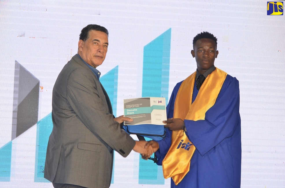 Mayor of Montego Bay , Councillor Homer Davis (left), presents a Certificate of Completion to Damalla Black,  at the western Event Production Training Programme graduation ceremony, held on Monday (December 16), at Grandiosa Hotel, Montego Bay, St. James.