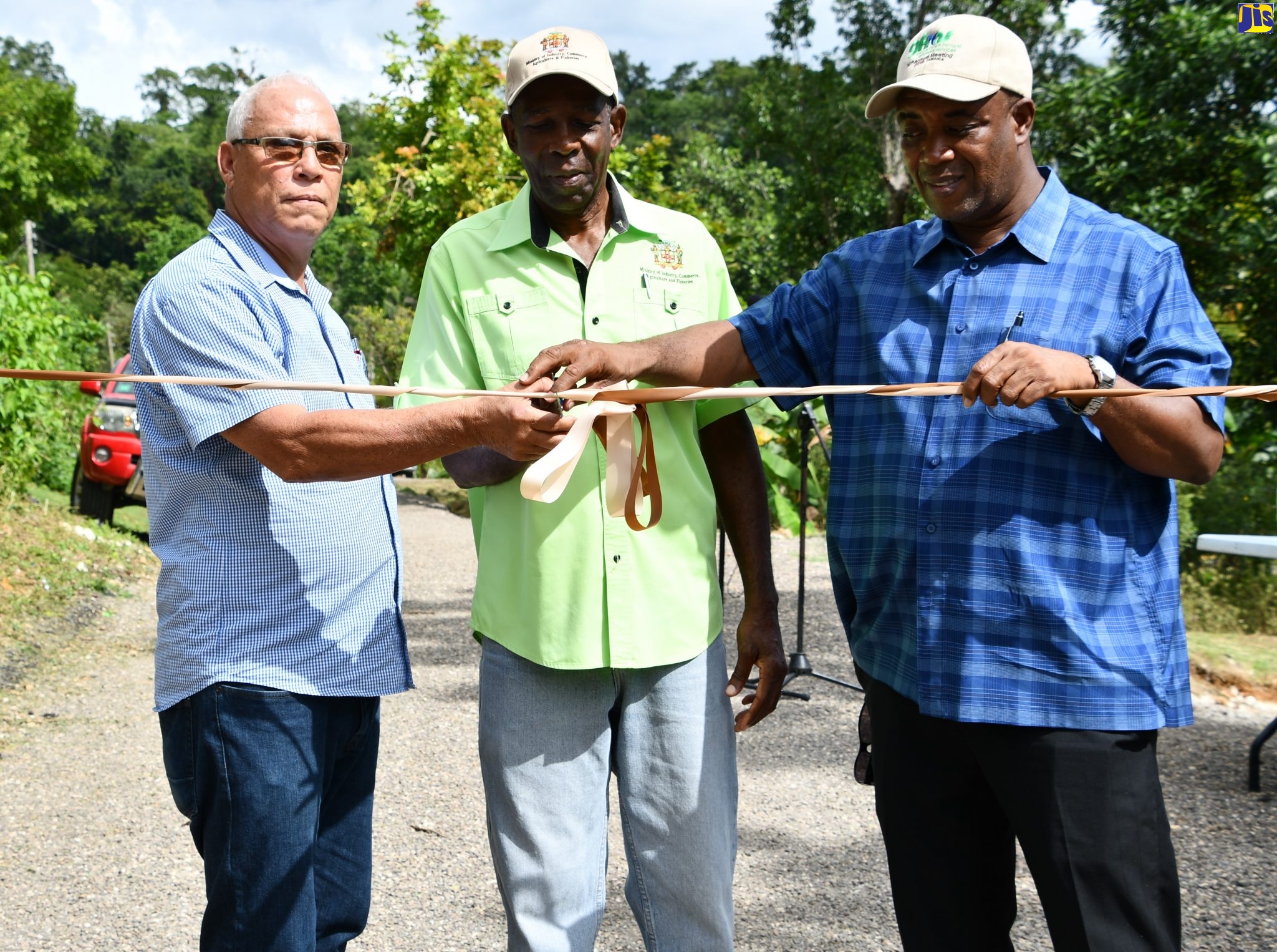 Minister without Portfolio in the Ministry of Industry, Commerce, Agriculture and Fisheries, Hon. J.C. Hutchinson (centre), cuts the ribbon to open the rehabilitated Marl Road community roadway, in Balaclava, St. Elizabeth, on Thursday (December 19). Sharing the moment are Chief Executive Officer of the Rural Agricultural Development Authority (RADA), Peter Thompson (right) and Member of Parliament for North East St. Elizabeth, Evon Redman. The road was repaired as part of the Ministry’s National Farm Road Programme.