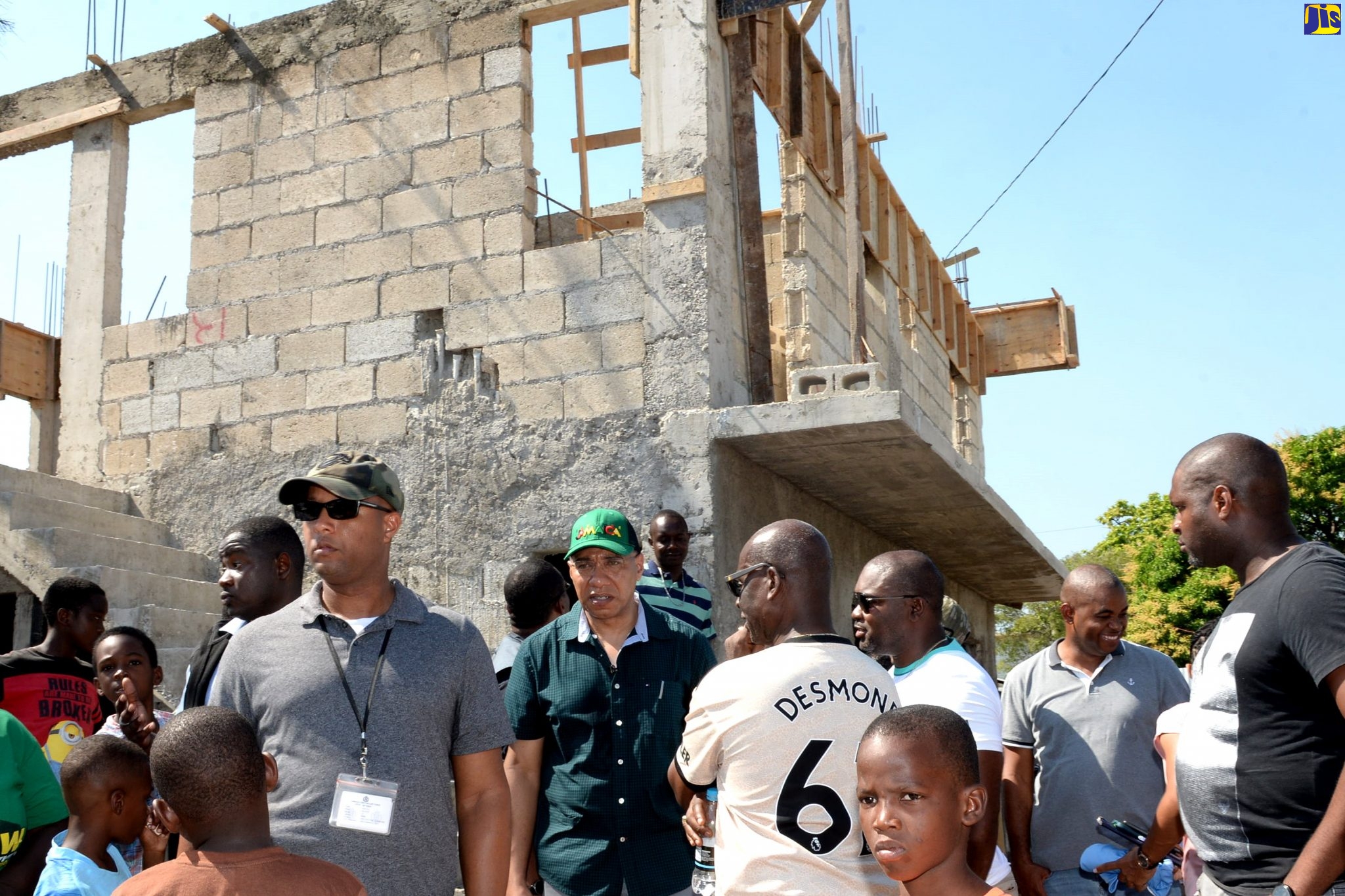 Prime Minister, the Most Hon. Andrew Holness (centre), in discussion with Minister of Local Government and Community Development, and Member of Parliament for West Kingston,  Hon. Desmond McKenzie (to his left),  at the construction site of a four-unit housing solution being constructed on Elgin Street in Denham Town, Kingston, for fire victims, on November 30.