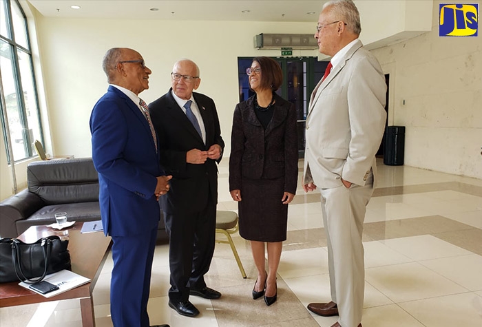 Minister of Justice, Hon. Delroy Chuck (right), in discussion with Executive Director of National Integrity Action (NIA), Professor Trevor Munroe (left), at a Justice of the Peace Sensitisation Session, held at the Montego Bay Convention Centre, St. James, on December 6. Others (from second left) are: United States Ambassador to Jamaica, Donald Tapia, and Permanent Secretary in the Ministry of Justice, Sancia Bennett Templer.