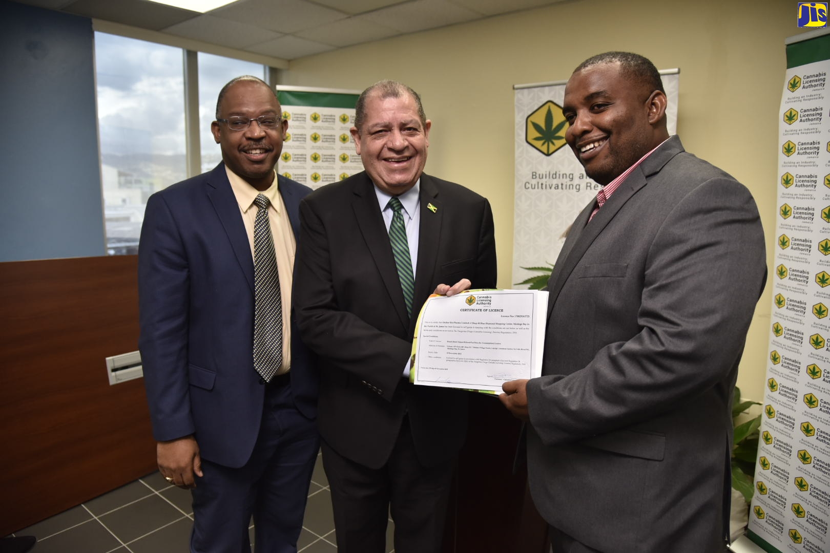 Minister of Industry, Commerce, Agriculture and Fisheries, Hon. Audley Shaw (centre), hands over the Cannabis Licensing Authority