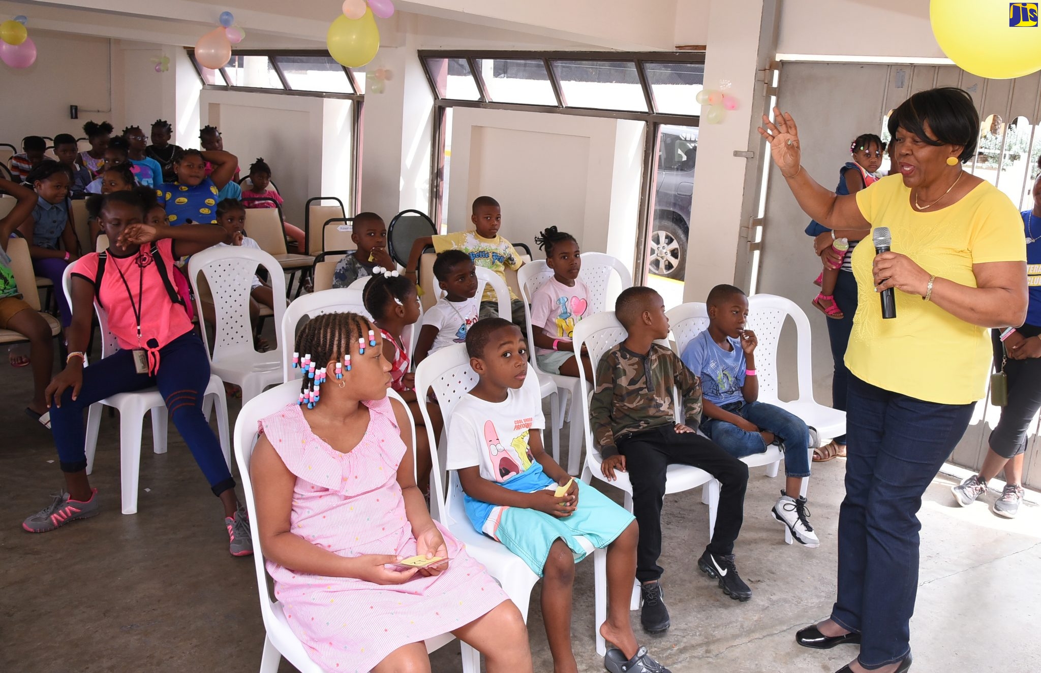 Deputy Clerk to the Houses of Parliament, Valrie Curtis (right), welcomes attendees to the annual Christmas treat for children, held in Parliament