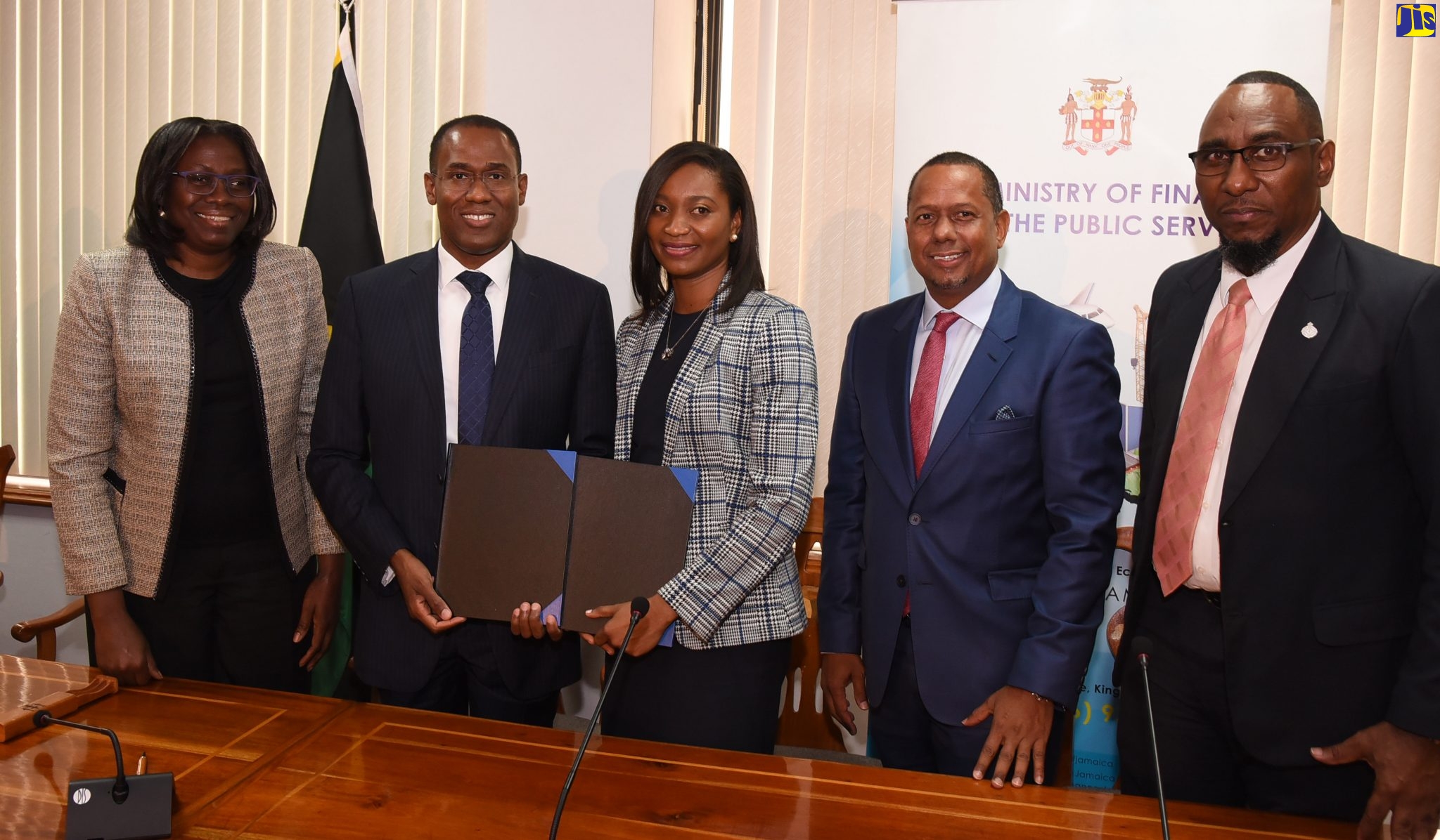 Minister of Finance and the Public Service, Dr. the Hon. Nigel Clarke (second left); and Country Managing Partner, Ernst and Young Jamaica Limited, Kayann Sudlow (third left), display two contracts, totaling US$7 million, which they signed to carry out a review of the public-sector compensation structure; and to implement shared corporate services for the public sector. Also pictured (from left) are Financial Secretary, Darlene Morrison; Executive Director, Ernst and Young, Barry Eligon; and President, Jamaica Civil Service Association (JCSA), O
