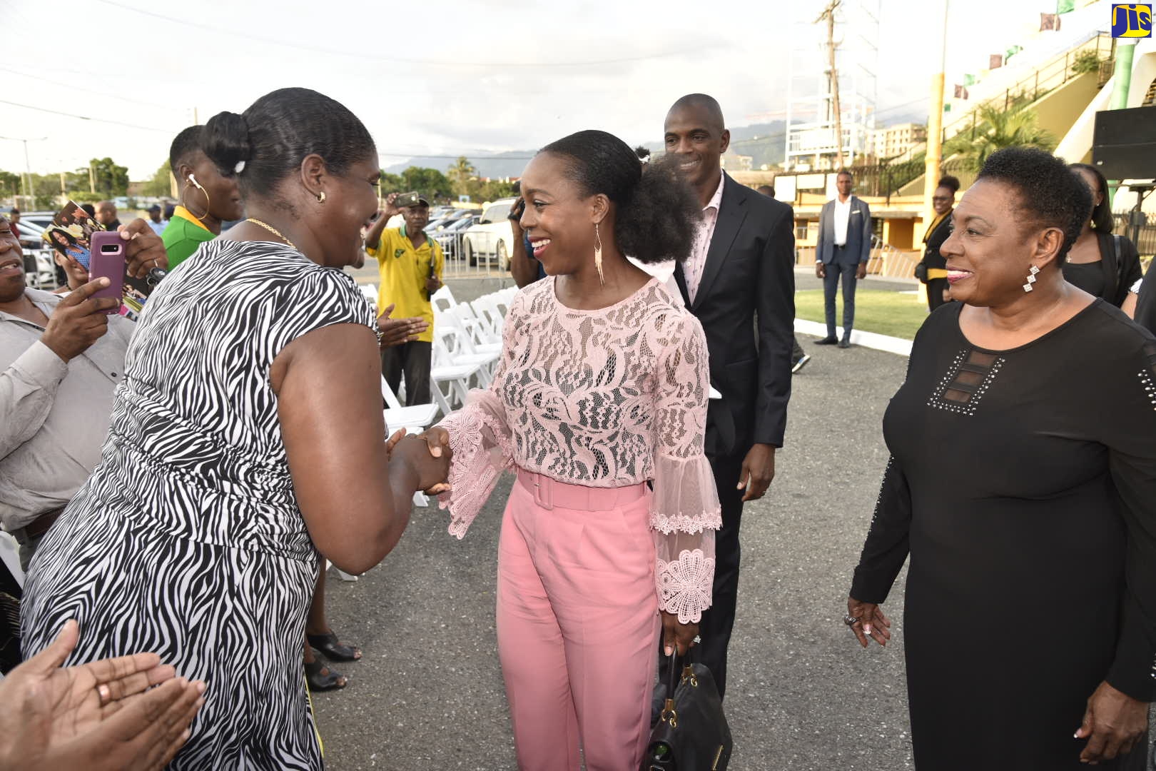 Minister of Culture, Gender, Entertainment and Sport, Hon. Olivia Grange (right), looks on as Olympian, Veronica Campbell-Brown (centre), is greeted by Principal of the Vere Technical High School, Antoinette Banton Ellis (left). They were at a ceremony at the National Stadium in October to unveil a statue in honour of the Olympian. In the background is Mrs. Campbell-Brown’s husband, Omar Brown.

