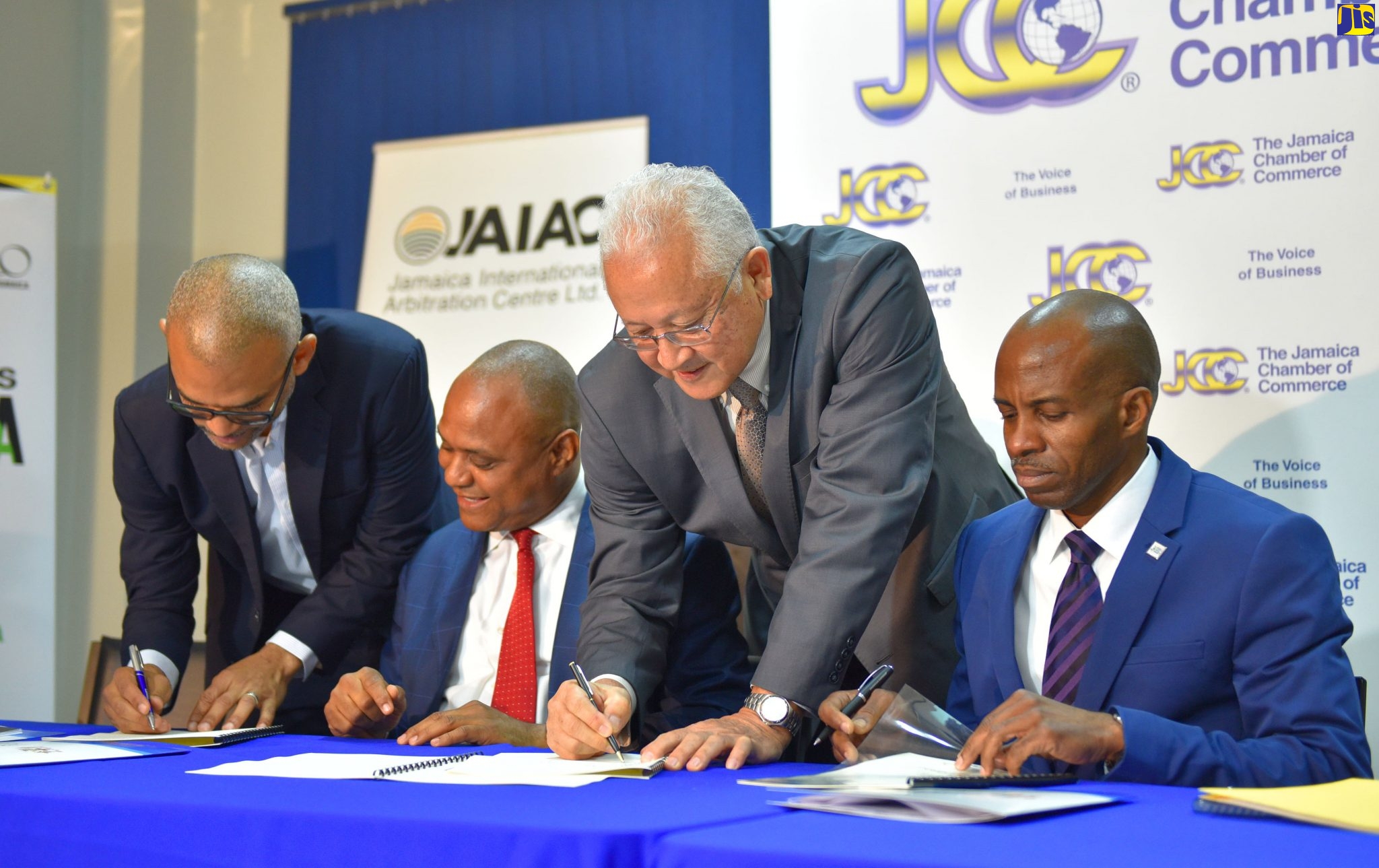 Minister of Justice, Hon. Delroy Chuck (2nd right) and Vice President for Marketing at the Jamaica Promotions Corporation (JAMPRO), Gabriel Heron (left), sign a Cooperation Framework Agreement for Alternative Dispute Resolution (ADR), at the JCC’s office in Kingston on Wednesday (Dec. 18). Other signatories were Secretary-General of the Jamaica International Arbitration Centre (JAIAC), Dr. Christopher Malcolm (2nd left), and President of the Jamaica Chamber of Commerce, Lloyd Distant Jr. (right)