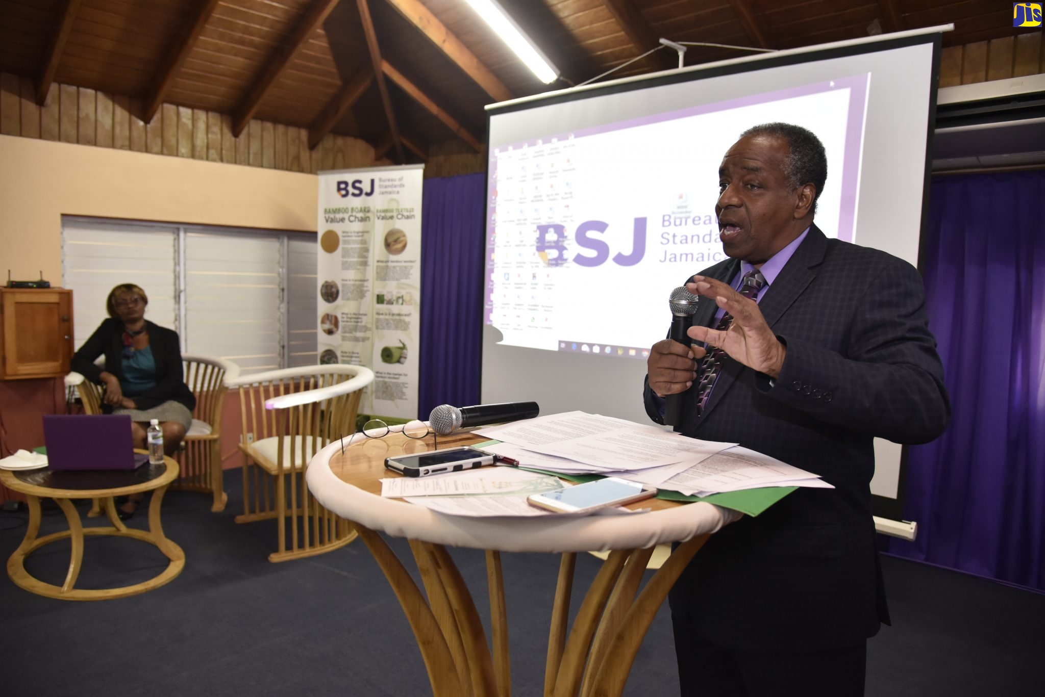 Director of Special Projects at the Bureau of Standards Jamaica (BSJ), Gladstone Rose (at podium), addresses a recent bamboo seminar held at the agency’s Winchester Road offices in St. Andrew. At left is researcher, Veronica Gayle-Ramsey.