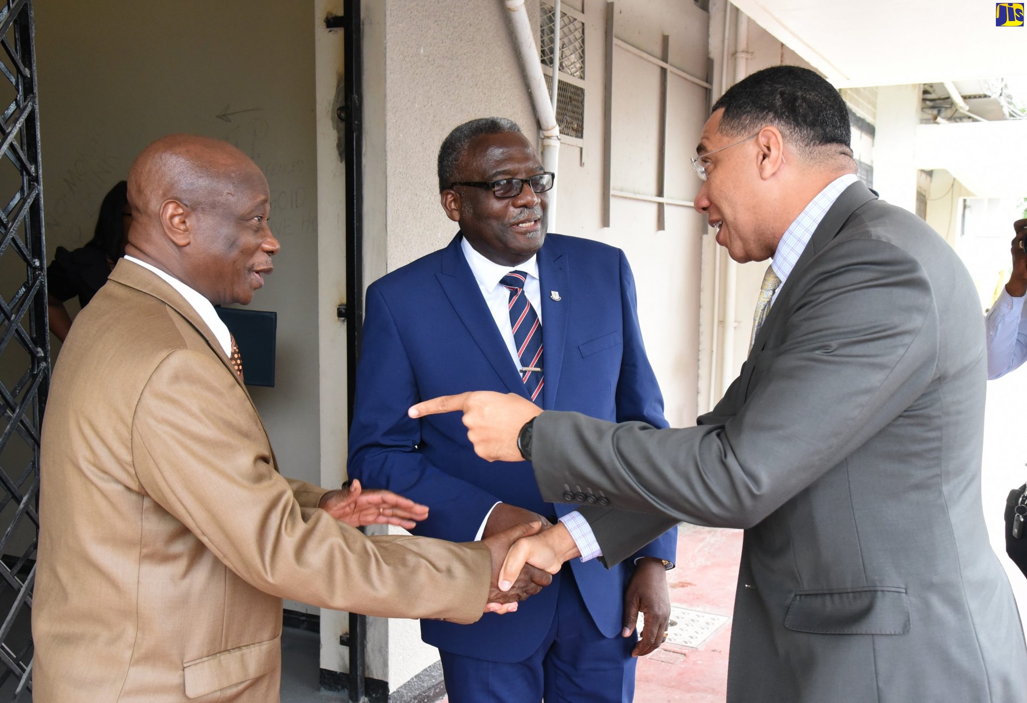 Prime Minister, the Most Hon. Andrew Holness (right), greets Chief Coordinator of the ‘Heal the Family, Heal the Nation’ 15th Annual National Gathering, Bishop Dr. Delford Davis (left),  and President of the Jamaica Umbrella Group of Churches, Bishop Conrad Pitkin,  on Wednesday (January 8), at the National Arena in Kingston.