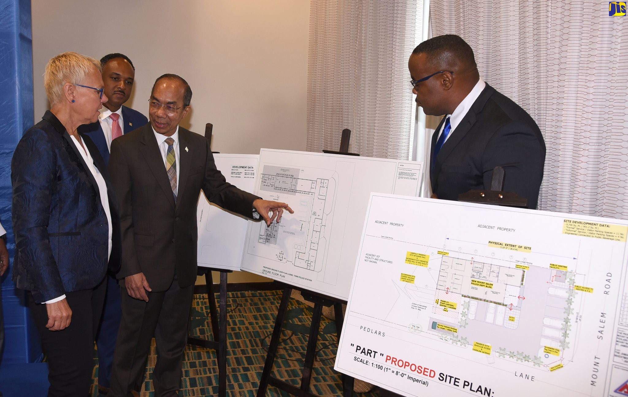 Minister of National Security, Hon. Dr. Horace Chang (third left), points to an architectural drawing of works to be carried out at a police station under the European Union (EU)-funded Poverty Reduction Programme (PRP), on Thursday (January 23), at the Courtyard by Marriott hotel in New Kingston. Sharing the moment (from left) are Head of Delegation of the European Union in Jamaica, Ambassador Malgorzata Wasilewska; Managing Director, Jamaica Social Investment Fund, Omar Sweeney and Commanding Officer of the Property Management and Maintenance Division, Jamaica Constabulary Force, Garfield Taylor. Six police stations are to be rehabilitated under the programme at a cost of $235 million.