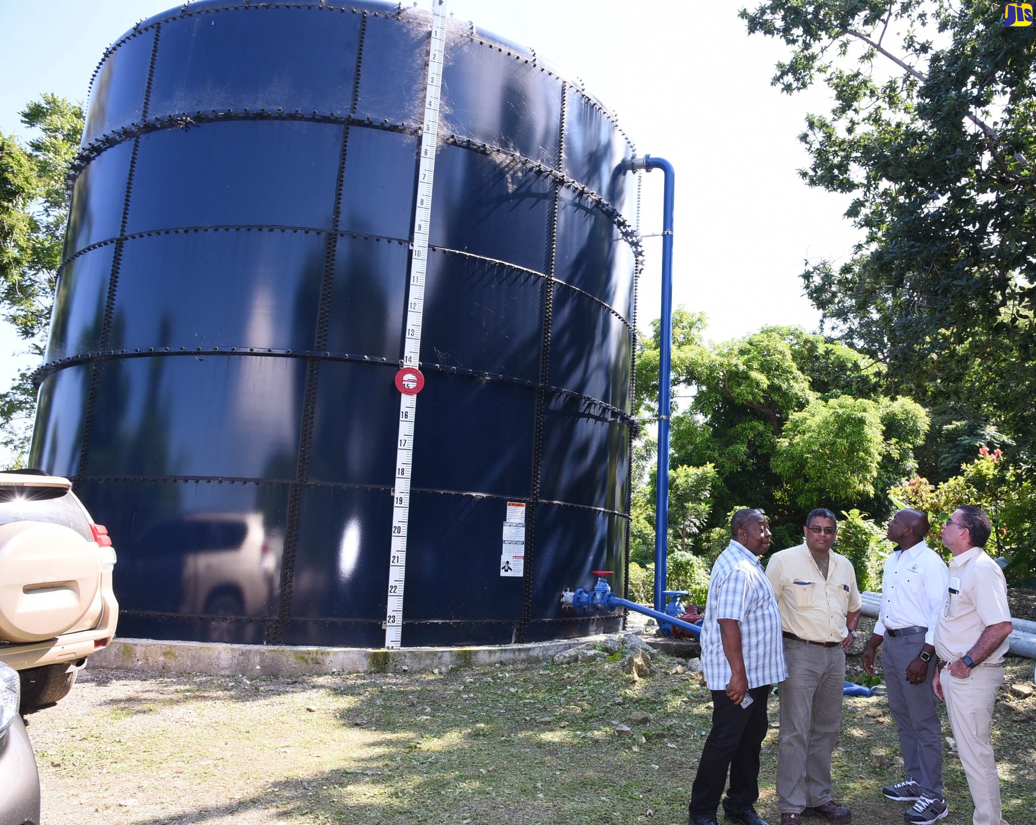 Ministers without Portfolio in the Ministry of Economic Growth and Job Creation, Senator the Hon. Pearnel Charles Jr (second right) and  Hon. Daryl Vaz (right), look at the newly installed 100,000-gallon tank for the Charles Town/Kildare water supply in Portland on Wednesday (January 29). Standing beside them are Managing Director, Rural Water Supply Limited (RWSL), Audley Thompson (left); and Managing Director, Water Resources Authority (WRA), Peter Clarke.