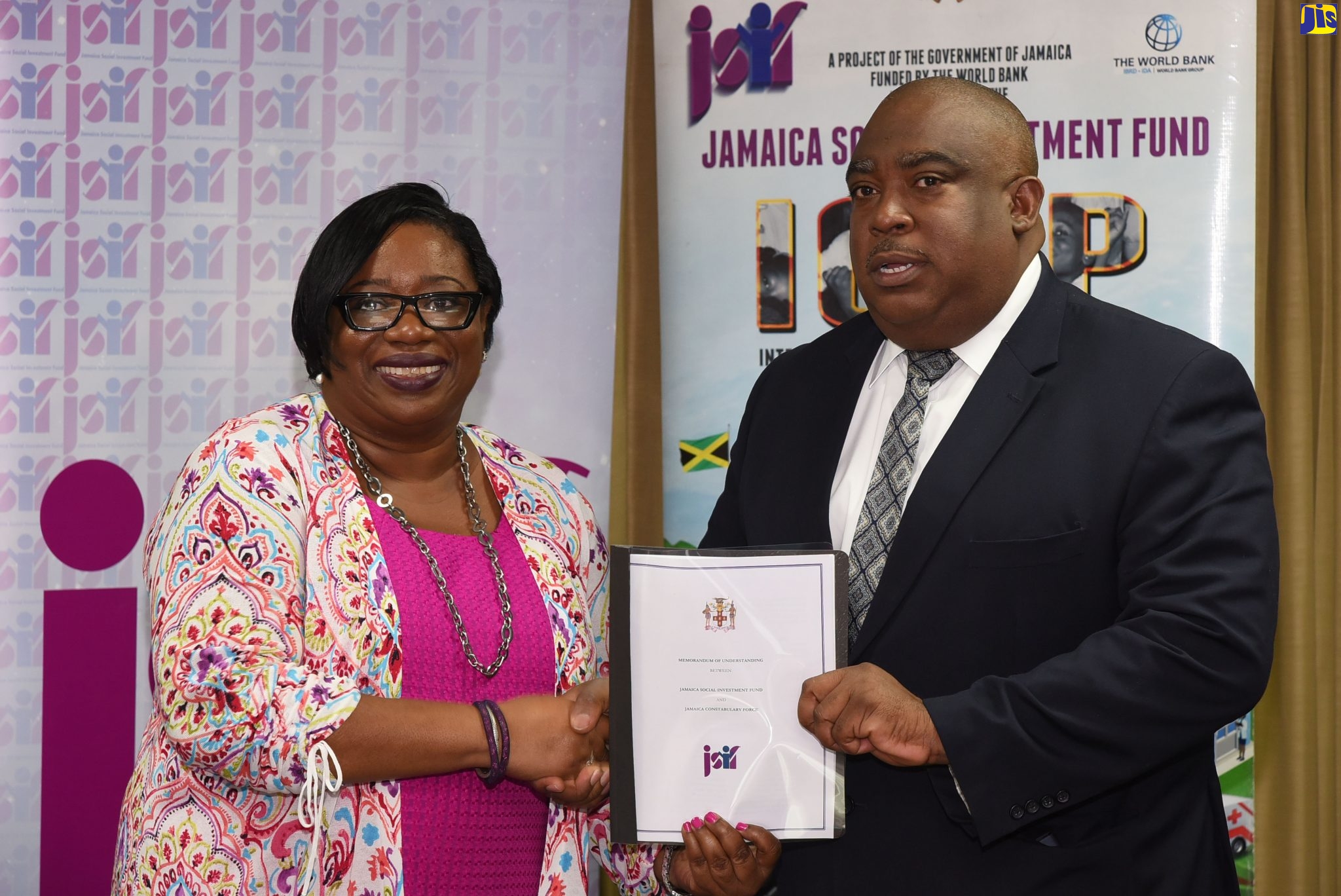 Social Development Manager, Jamaica Social Investment Fund (JSIF), Mona Sue-Ho (left), presents Acting Deputy Commissioner of Police, Richard Stewart, with a signed copy of a memorandum of understanding (MOU) between the entities, for the provision of additional funding for the Jamaica Crime Observatory (JCO) Enhancement Project. The signing was held on Wednesday (January 22) at the JSIF