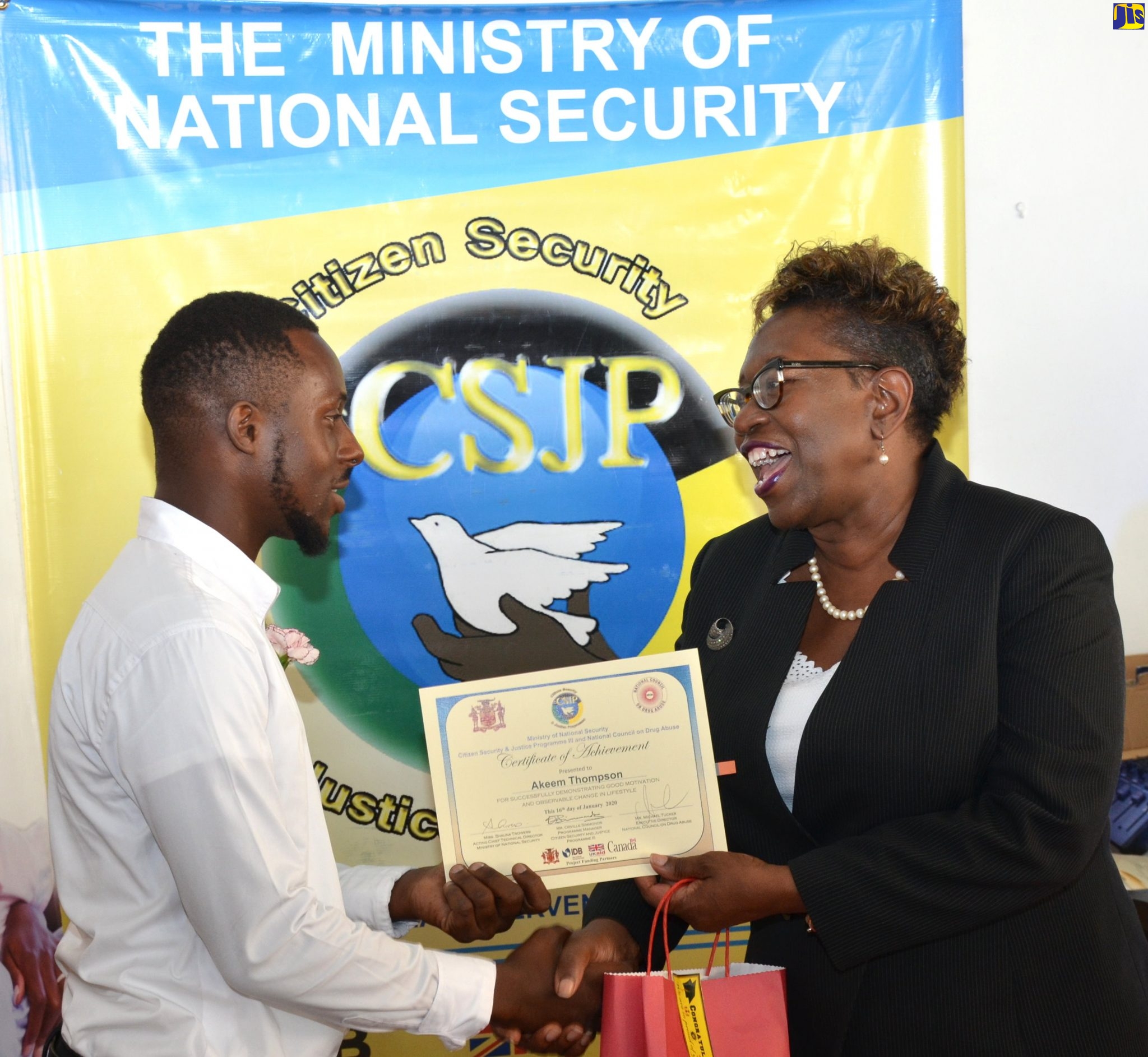 Director of Public Prosecutions, Paula Llewellyn (right) presents participant in the National Council on Drug Abuse (NCDA) programme, Akeem Thompson with a certificate of achievement at the programme’s closing exercise held on Thursday (January 16) at the Jamaica Conference Centre, Downtown Kingston.
