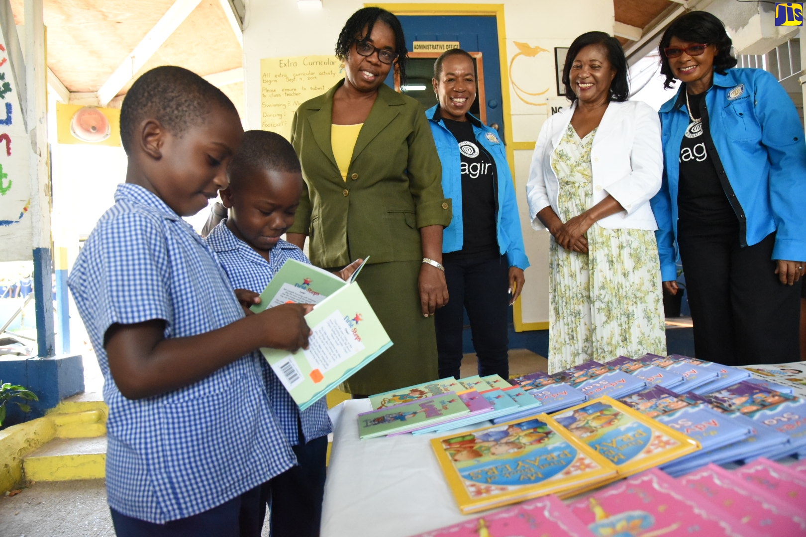 Wife of the Governor-General, Her Excellency, the Most Hon. Lady Allen (second right) looks on as K2 students of the Jamaica House Basic School, Beshawn Blairgrove (left); and Garey Dawkins (second left), scan books donated to the school by the Optimist Club of Kingston.  The presentation ceremony was held on Thursday (February 6), at the school