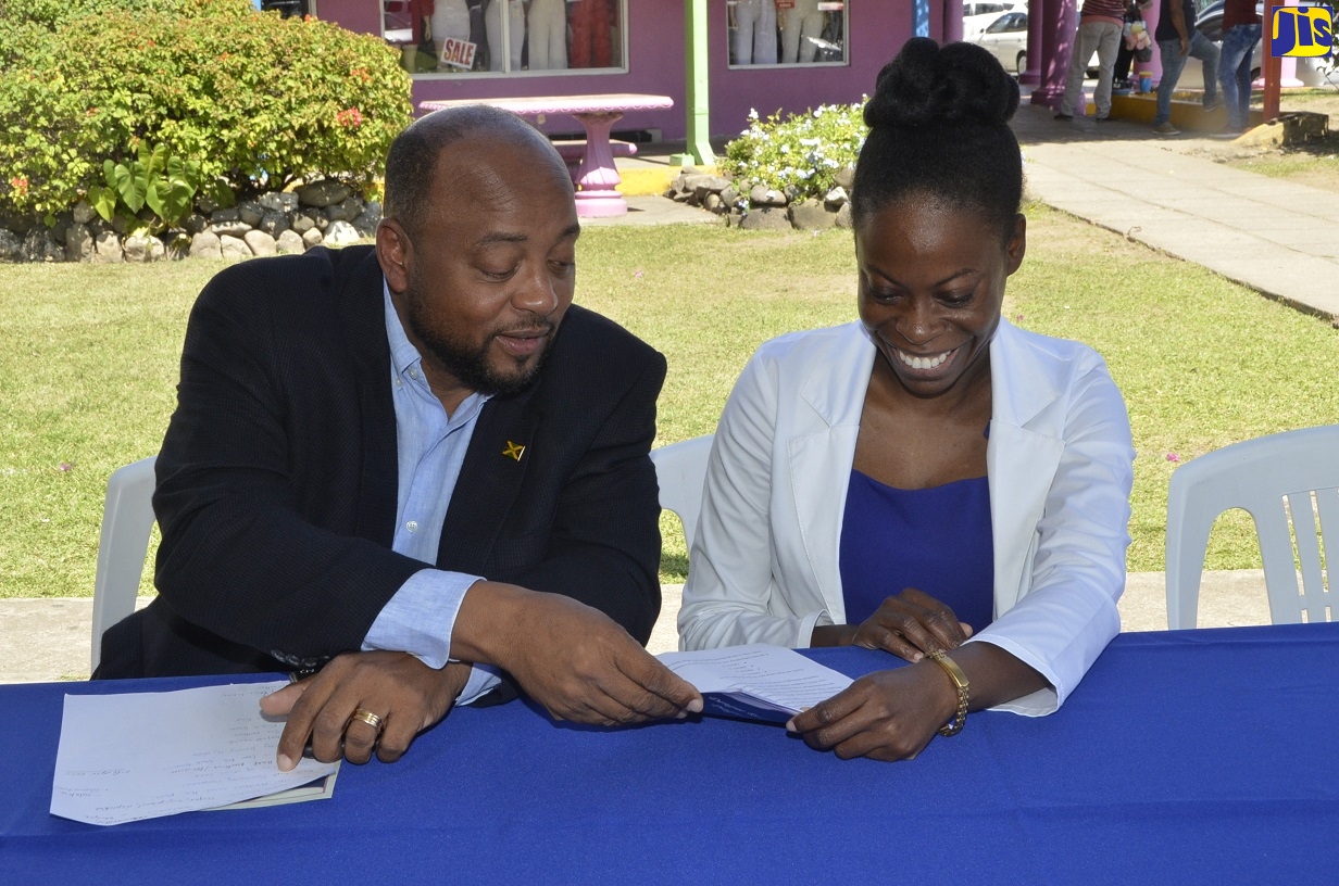 Mayor of St. Ann’s Bay, Councillor Michael Belnavis, converses with Dr. Tamika Henry of the North East Regional Health Authority (NERHA) at the launch of a Dengue Response Programme for the parish at Ocean Village Shopping Centre in Ocho Rios on February 14.