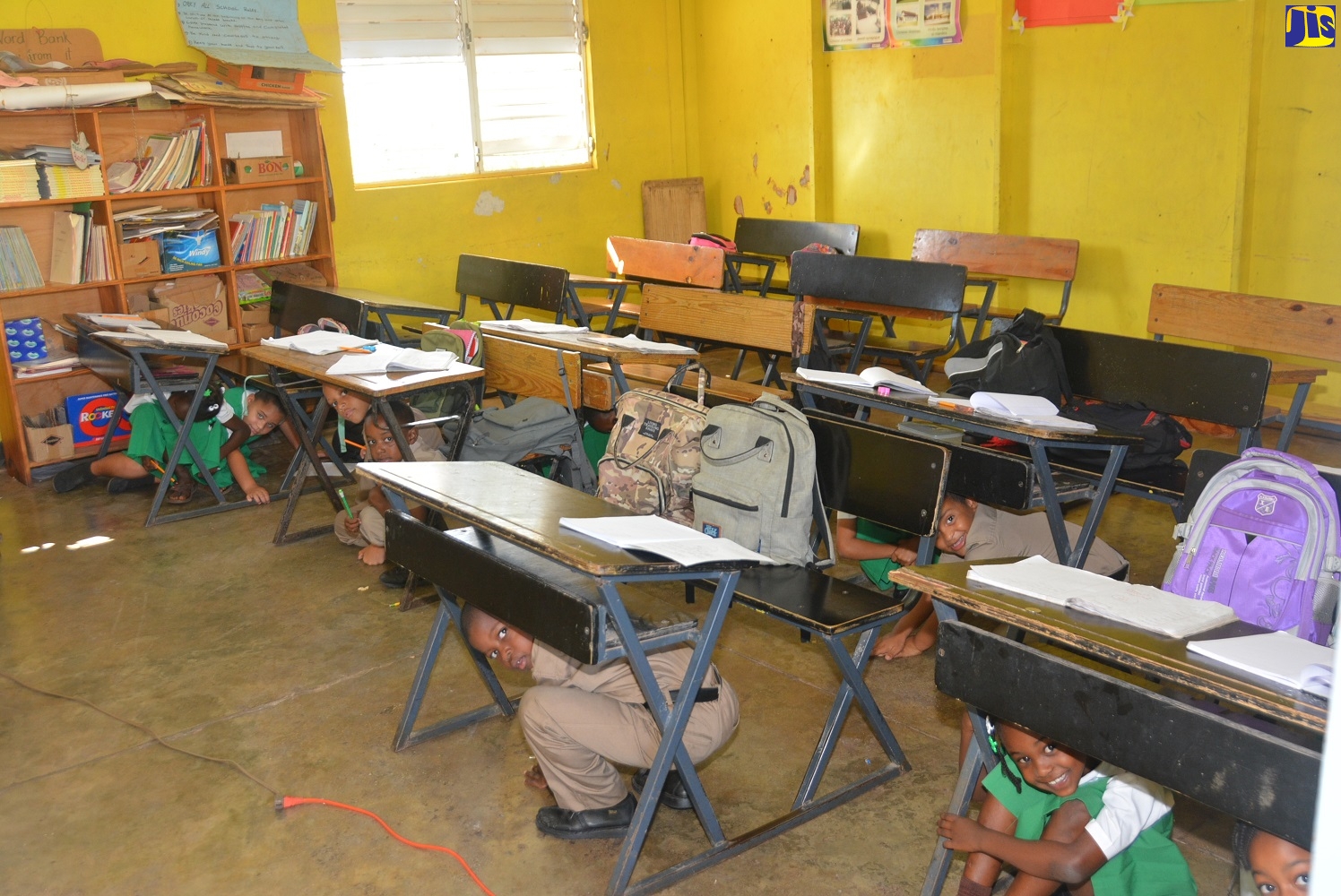 Students executing the earthquake duck, cover and hold method, during an earthquake simulation exercise at the Sandy Bank Primary School in Treasure Beach, St. Elizabeth, on Friday (January 31).