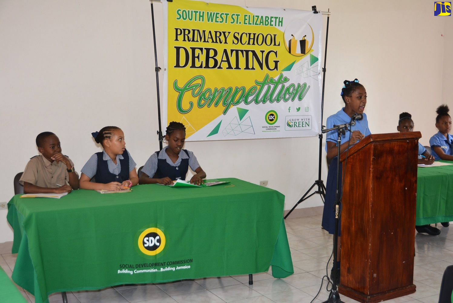 Mountainside Primary School student,  Natallia Samuels (podium), leads her team in debate against Pedro Plains Primary in the finals of the inaugural South West Primary School Debate Competition at the Black River Parish Library in St. Elizabeth on Thursday (February 13).  Mountainside Primary School won the competition.