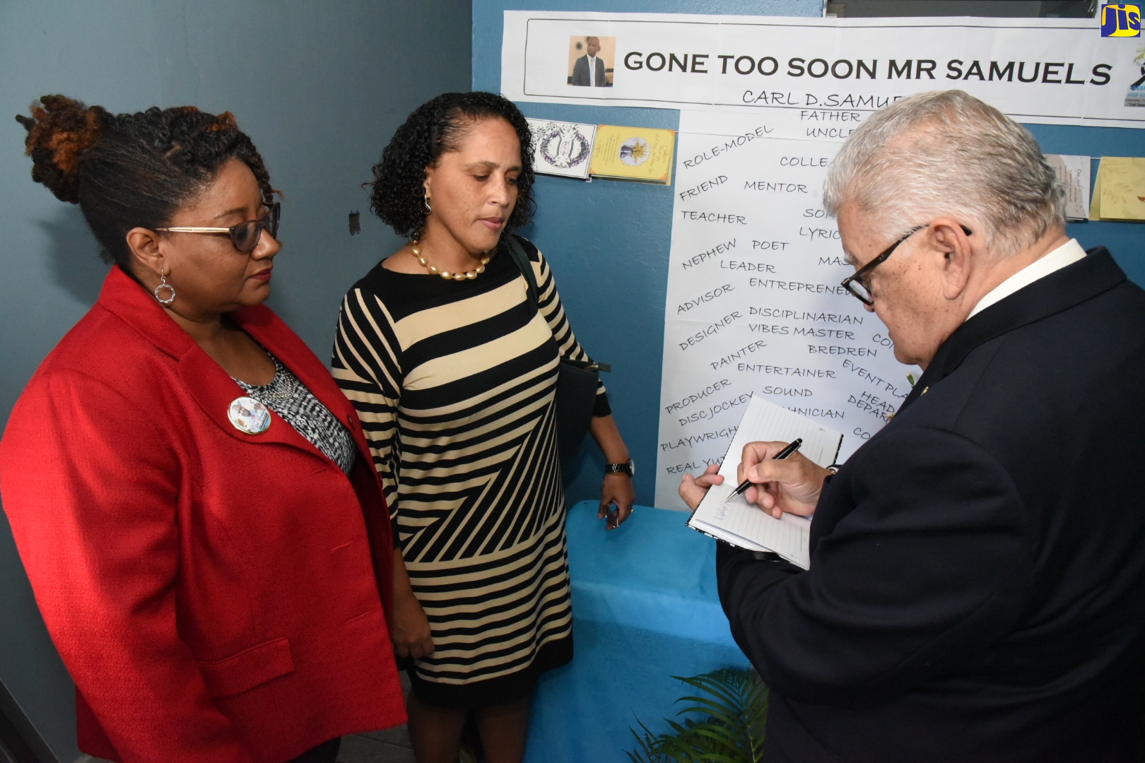 Minister with responsibility for Education, Youth and Information, Hon. Karl Samuda, signing the condolence book for slain teacher, Carl Samuels, at Vauxhall High School in Kingston during a visit to the institution on Wednesday (February 5). Looking on (from left) are Principal, Prudence Brown Pinnock; and Director for the Education Ministry’s Region One, Allison Hawthorn-Cooke.