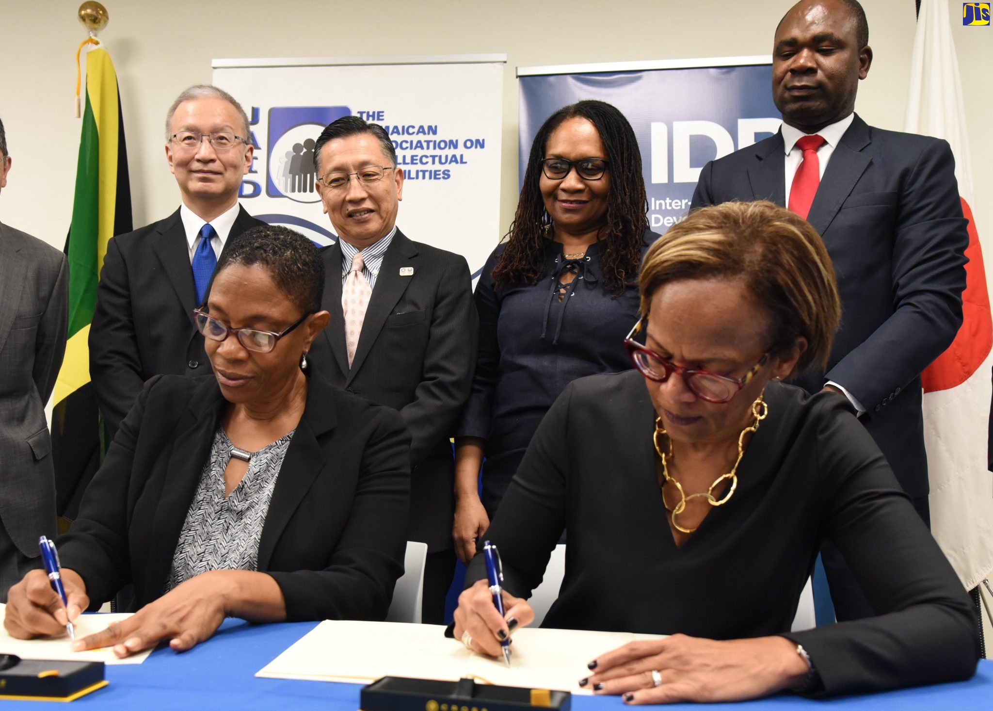 Executive Director of the Jamaica Association on Intellectual Disabilities (JAID), Marilyn McKoy (seated, left) and Country Representative, Jamaica and General Manager, Caribbean Country Department, Inter-American Development Bank (IDB), Therese Turner-Jones (seated, right) sign the ‘Innovative Approaches to the Development of Children with Intellectual Disabilities’ technical cooperation agreement, at a ceremony held at the IDB’s Montrose Road offices in Kingston, today (February 10). Observing (from left, standing) are: IDB Executive Director for Japan, Toshiyuki Yasui; Ambassador of Japan to Jamaica, His Excellency Hiromasa Yamazaki; Project Team Leader, IDB for the Innovative Approaches to the Development of Children with Intellectual Disabilities programme, Charmaine Edmondson-Nelson; and State Minister in the Ministry of Labour and Social Security, Hon. Zavia Mayne.