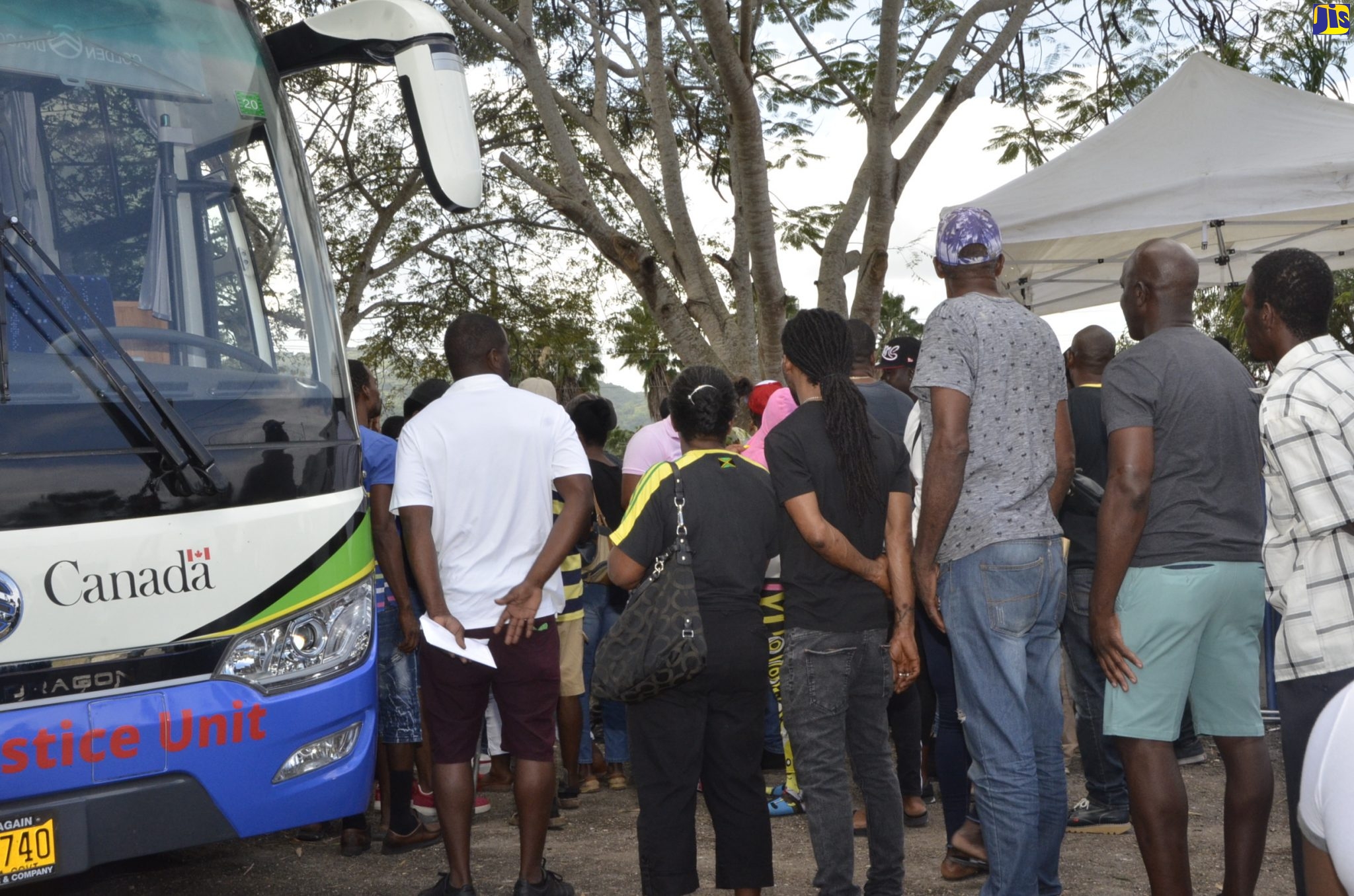 Members of the public line up to enter one of the Legal Aid Council’s (LAC) mobile units, during an expungement fair held at Alice Eldemire Drive in Bogue, St. James on Friday (February 21).