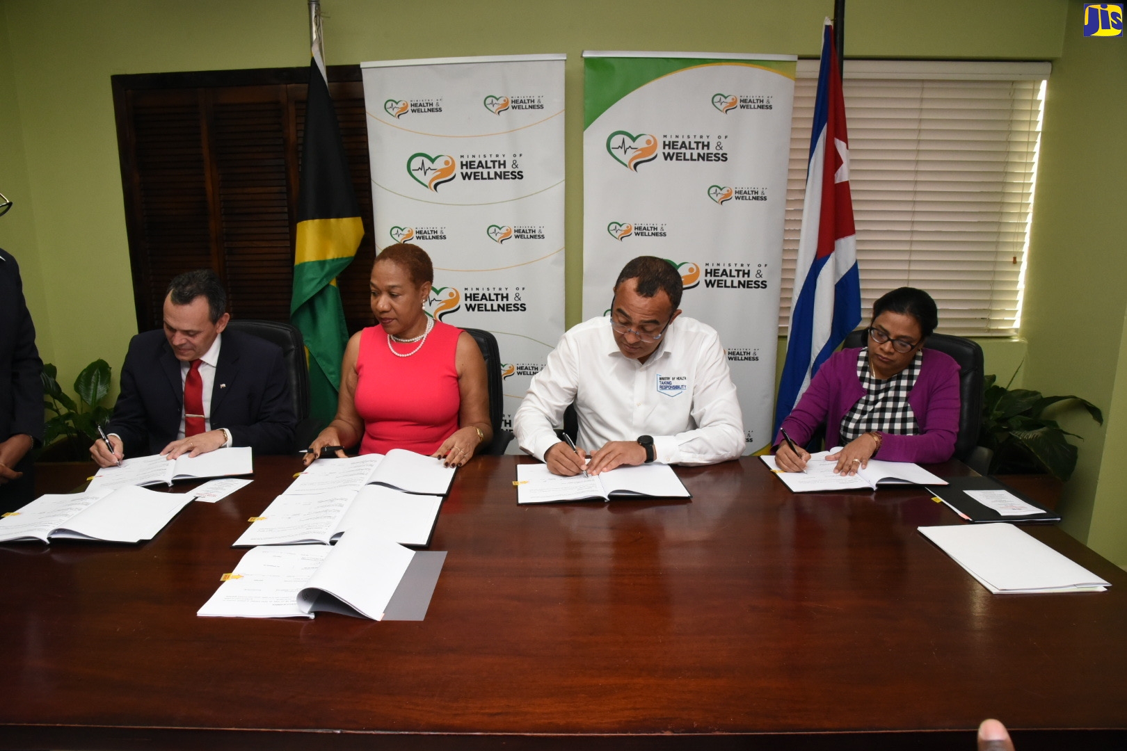 Minister of Health and Wellness, Dr. the Hon. Christopher Tufton (second right) signs a document renewing the Technical Cooperation Agreement with the Ministry of Public Health of the Republic of Cuba, during a ceremony held at the New Kingston offices of the Ministry, on Tuesday (February 25). Also participating (from left) are National Coordinator for the Cuban Medical Brigade in Jamaica, Dr. José Armando Arronte Villamarin; Ambassador of Cuba to Jamaica, Her Excellency Inés Fors Fernández; and Chief Medical Officer, Dr. Jacquiline Bisasor McKenzie.