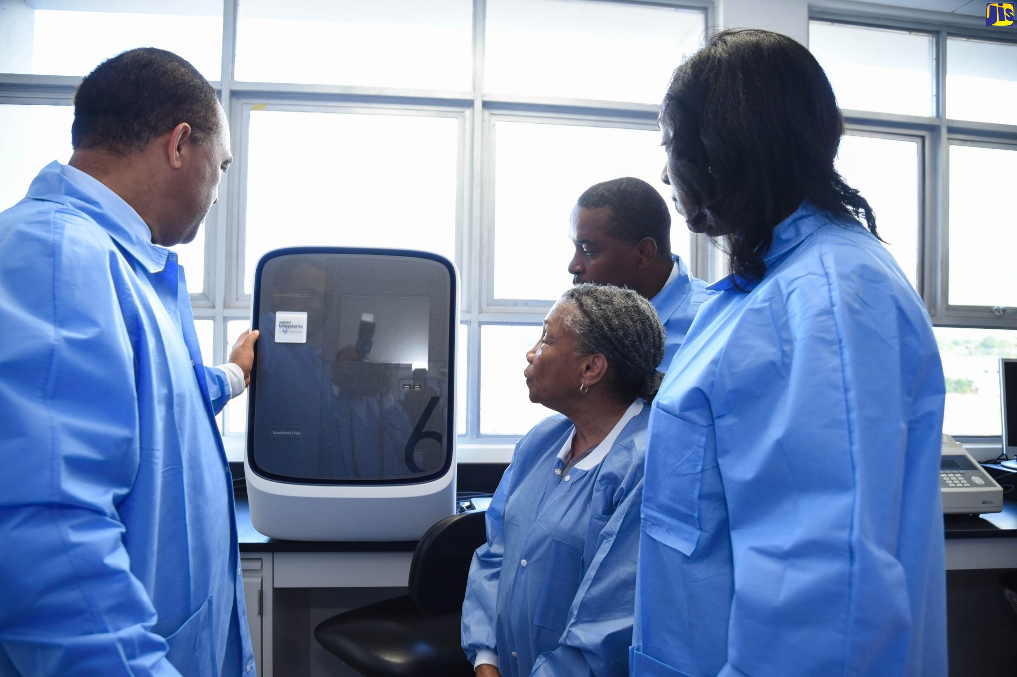 Minister of Health and Wellness, Dr. the Hon. Christopher Tufton (left), tries out a thermal cycler while on a tour of the National Influenza Centre (NIC) at the University Hospital of the West Indies (UHWI) on Monday (February 17). Looking on (from second left) are Medical Chief of Staff and Consultant Neurosurgeon at the UHWI, Dr. Carl Bruce; Director of the NIC, Professor Monica Smikle; and acting head of the National Public Health Laboratory, Dr. Michelle Hamilton.