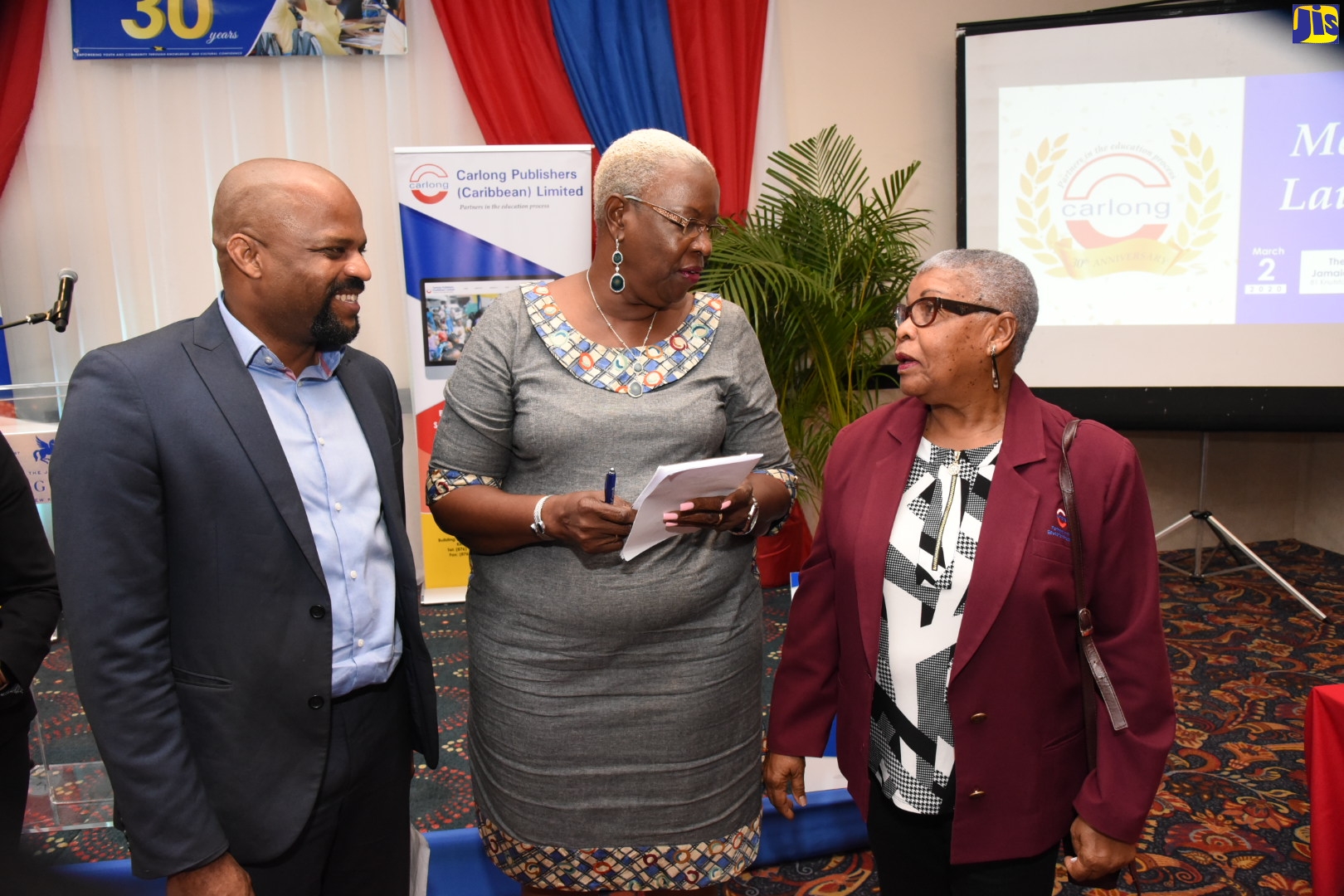 Senior Advisor at the Ministry of Education, Youth and Information, Courtney Scott (left), observes as Chairman of Carlong Publishers (Caribbean) Limited, Shirley Carby (right), makes a point to Publishing Manager at the company, Sonia Bennett, at the media launch for the company’s 30th anniversary events, held yesterday (March 2), at The Jamaica Pegasus hotel in New Kingston.
