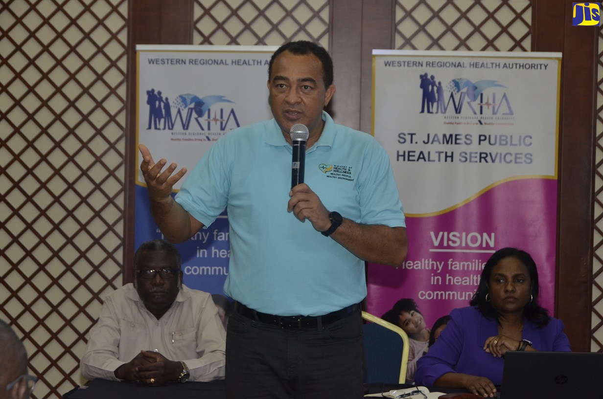 Minister of Health and Wellness, Dr. the Hon. Christopher Tufton (centre), speaks at a meeting with stakeholders in western Jamaica, at the Montego Bay Convention Centre, St. James, on Friday (March 13). Listening (from left) are Custos of St. James, Bishop the Hon. Conrad Pitkin; and Regional Technical Director, Western Regional Health Authority (WRHA), Dr. Dianne Campbell Stennett.