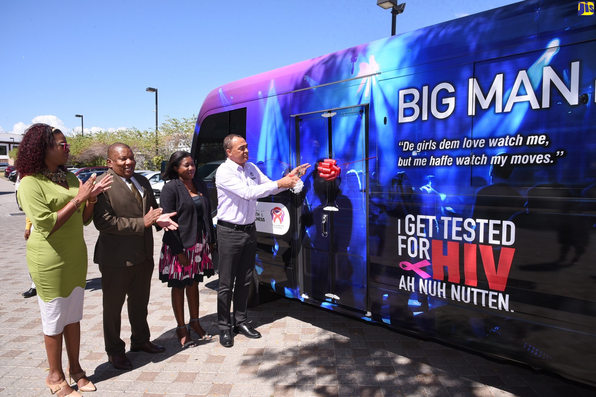 Minister of Health and Wellness, Dr. the Hon. Christopher Tufton (right), cuts the ribbon to symbolise the official handover of an HIV mobile testing unit to the Southern Regional Health Authority (SRHA) during a ceremony at the Courtyard by Marriott in New Kingston on Thursday (February 27). Sharing the moment (from left) are Director, Health Promotion and Protection in the Ministry, Dr. Simone Spence; Regional Director, Southern Regional Health Authority (SRHA), Michael Bent; and Acting Senior Medical Officer, Dr. Alisha Robb-Allen.