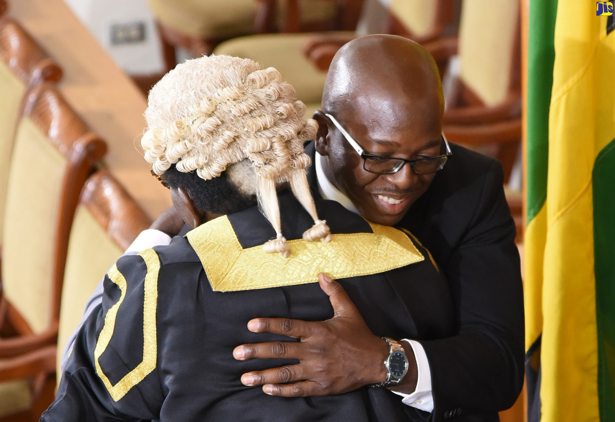 New Member of Parliament for South East Clarendon, Pearnel Charles Jr. is embraced by his father and Speaker of the House of Representatives, Pearnel Charles Sr. after he took the Oath of Office during the sitting of the House of Representatives on March 12.
