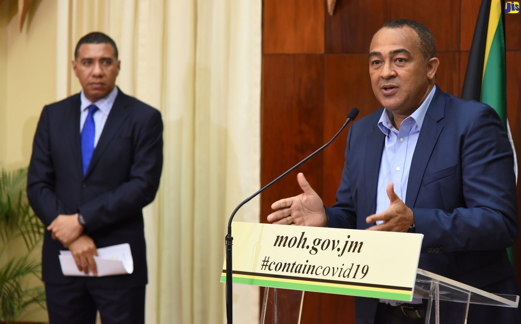 Prime Minister, the Most Hon. Andrew Holness (left), listens as Minister of Health and Wellness, Dr. the Hon. Christopher Tufton, provides an update on Jamaica’s Coronavirus (COVID-19) response, during a press conference at Jamaica House on Monday (March 23).