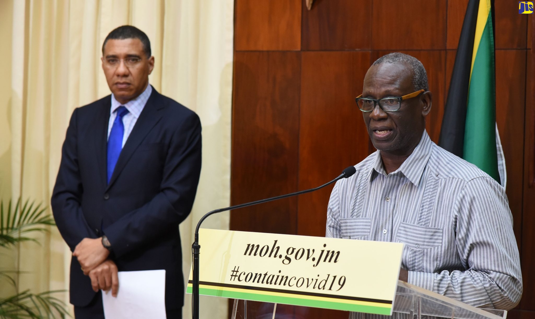 Minister of Local Government and Community Development, Hon. Desmond McKenzie (right), outlines Coronavirus (COVID-19) safeguards being implemented by the Ministry to protect the indigent, during a press conference at Jamaica House on Monday (March 23).  Listening is Prime Minister, the Most Hon. Andrew Holness,  who also addressed the press conference.