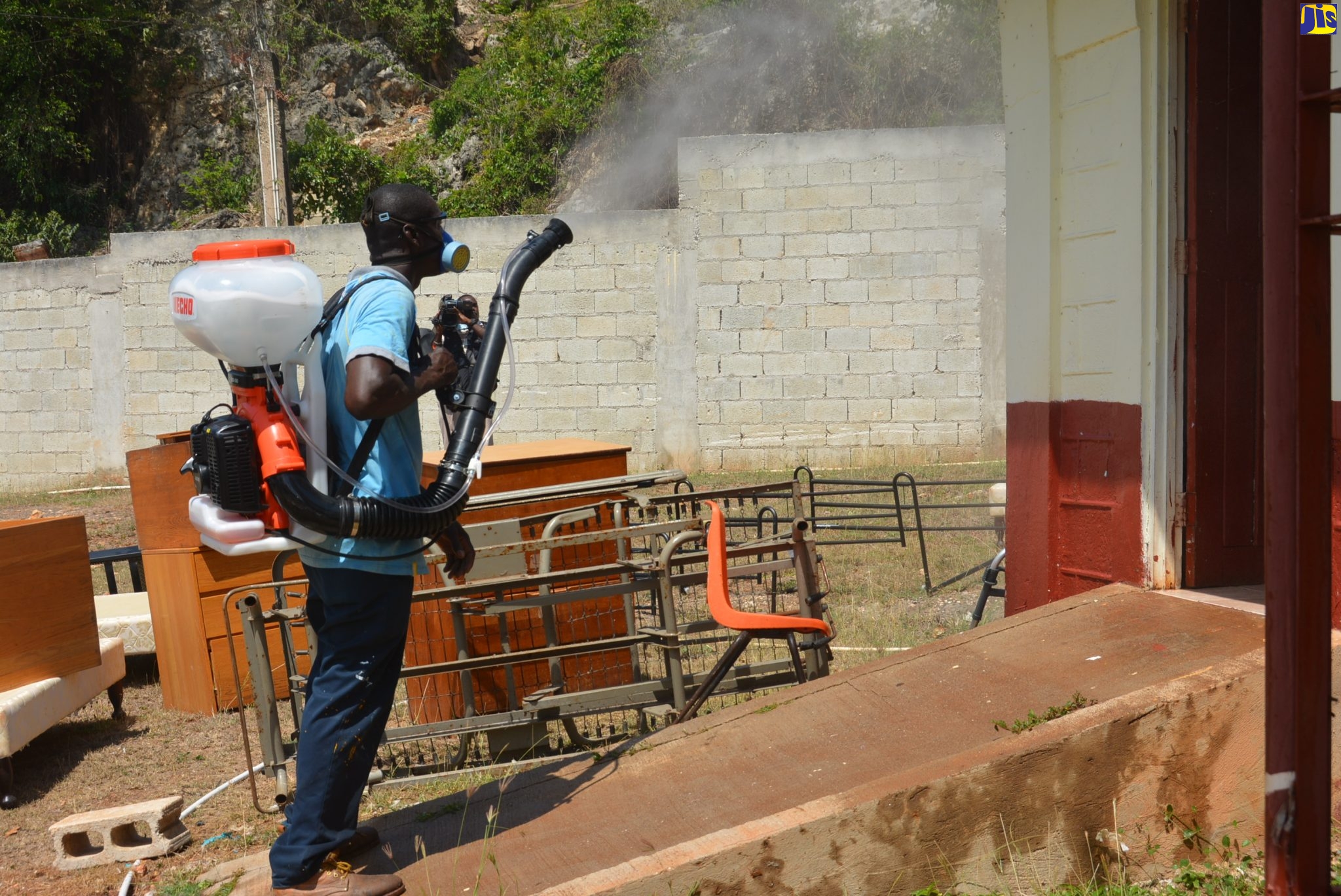 St. James Municipal Corporation staff member, Jerome Taylor, sprays the front wall of the female ward at the St. James Infirmary in Montego Bay as part of sanitisation activities at the facility on Wednesday (April 1).