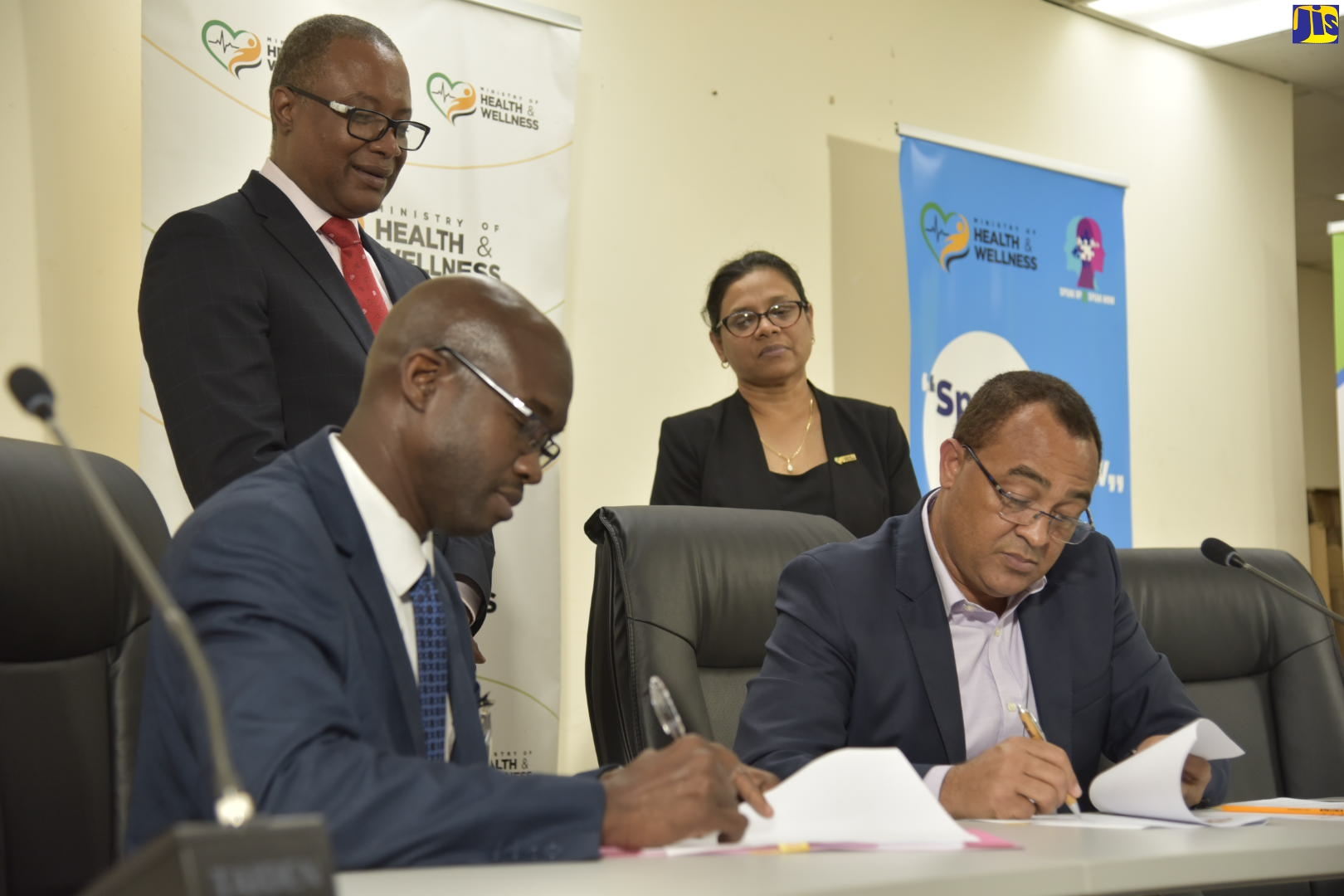 Minister of Health and Wellness, Dr. the Hon. Christopher Tufton (right) signs a Memorandum of Understanding with President and Chief Executive Officer, Andrews Memorial Hospital, Dr. Lindon Leach (left), during a digital press conference at the Ministry, in Kingston, on Tuesday (April 7). Observing are: Permanent Secretary in the Ministry, Dunstan Bryan and Chief Medical Officer, Dr. Jacquiline Bisasor McKenzie.