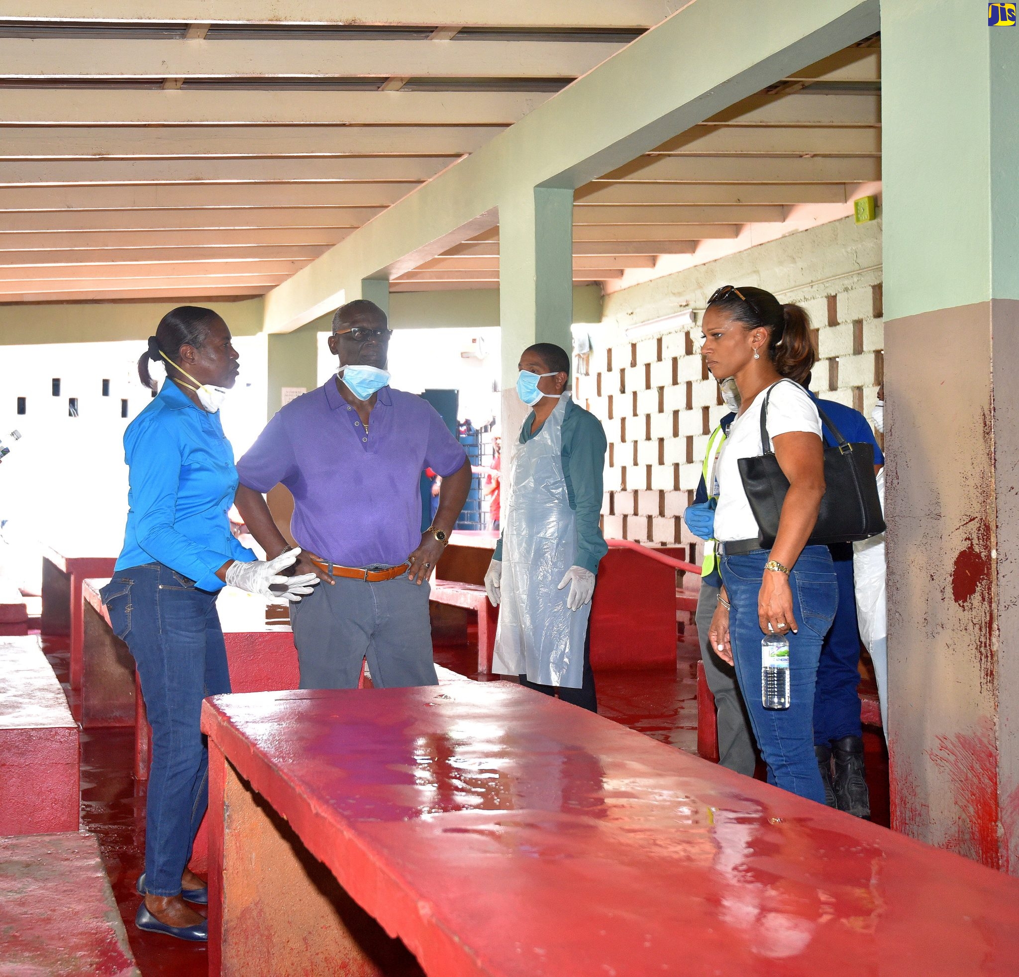 Minister of Local Government and Community Development, Hon. Desmond McKenzie (2nd left), is briefed by Inspector of Poor, Kingston and St. Andrew Municipal Corporation, Mavis Farquharson (left), on the work undertaken to sanitize the Marie Atkins Night Shelter on Hanover Street in downtown Kington on April 3. At right is Acting Director of Emergency Medical Services in the Ministry of Health and Wellness, Dr. Kurdell Espinosa-Campbell.