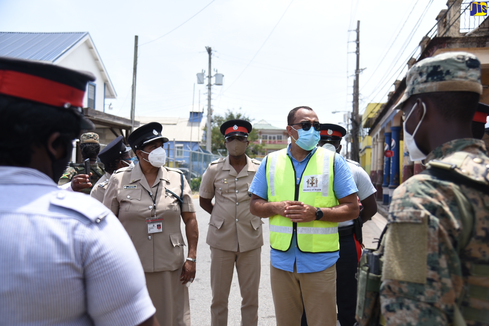 Minister of Health and Wellness, Dr. the Hon. Christopher Tufton (centre), meets with members of the security forces, who are manning check points in sections of St. Mary, that are under a 14-day quarantine. Dr. Tufton visited the areas on Saturday (May 9).