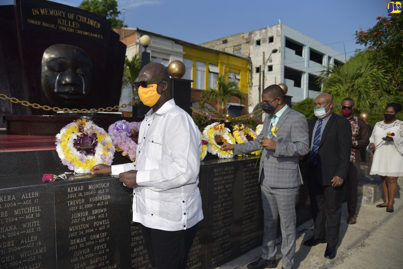 Minister of Local Government and Community Development, Hon. Desmond McKenzie (left), and Kingston’s Mayor, Senator Councillor Delroy Williams (2nd left), head officials laying flowers at the Secret Garden Monument in downtown Kingston during a ceremony on Sunday (May 3) in memory of the nation’s children who have died under tragic and violent circumstances. The event was organized by the Kingston and St. Andrew Municipal Corporation (KSAMC) as part of activities commemorating Child Month during May under the theme: ‘Unplug Negativity, Connect Positivity… Think!!!’.