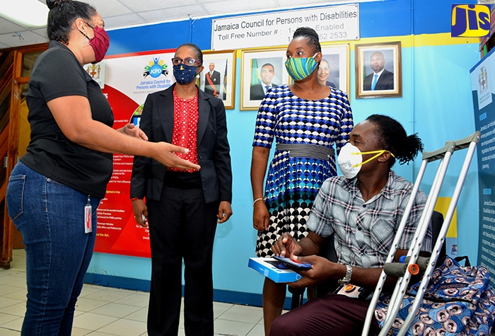 Chief Executive Officer of the Digicel Foundation, Charmaine Daniels (left), speaks with (from left) Chief Technical Director in the Ministry of Labour and Social Security, Dionne Jennings; Executive Director of the Jamaica Council for Persons with Disabilities (JCPD), Dr. Christine Hendricks; and University of Technology (UTech) student, Leron Williams. Occasion was a ceremony for the handing over of 10 tablets and data plans by the Digicel Foundation to assist students with special needs, at the JCDP offices on Ripon Road, St. Andrew, on Thursday (May 7).