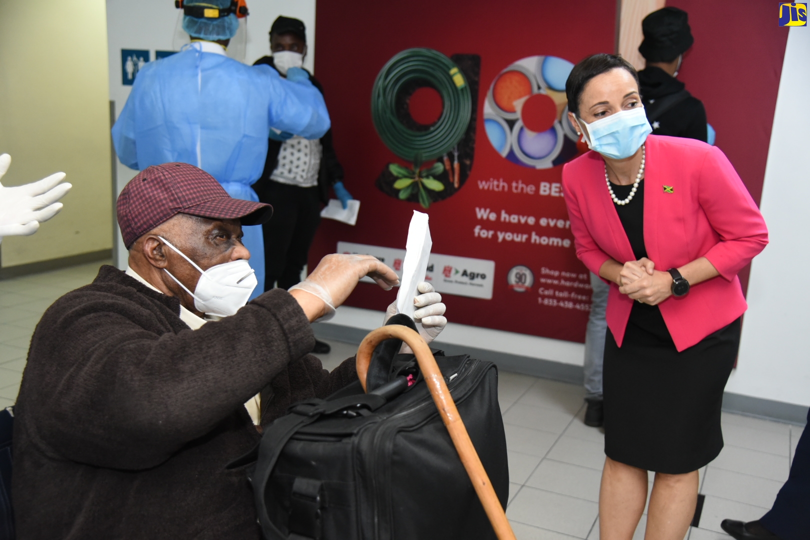 Minister of Foreign Affairs and Foreign Trade, Senator the Hon. Kamina Johnson Smith (right), directs a disabled repatriated Jamaican who returned from the United Kingdom on Wednesday (May 6), at the Norman Manley International Airport, in Kingston.