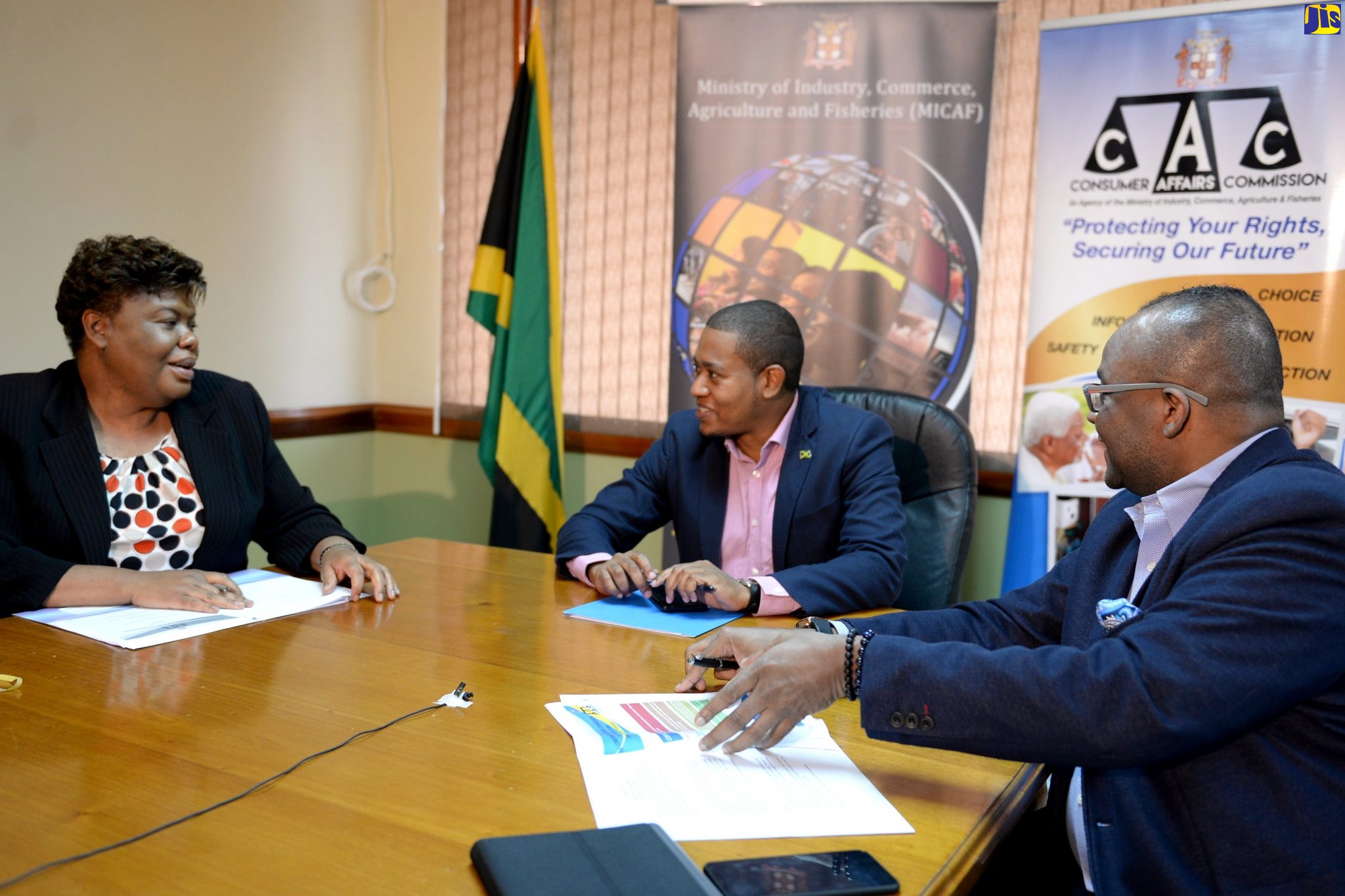 ave Reid Photo
State Minister in the Ministry of Industry, Commerce, Agriculture and Fisheries, Hon. Floyd Green (centre), engages with Chief Executive Officer of the Consumer Affairs Commission (CAC), Dolsie Allen (left),  during at virtual press briefing on Friday (May 22), to outline details of the Government