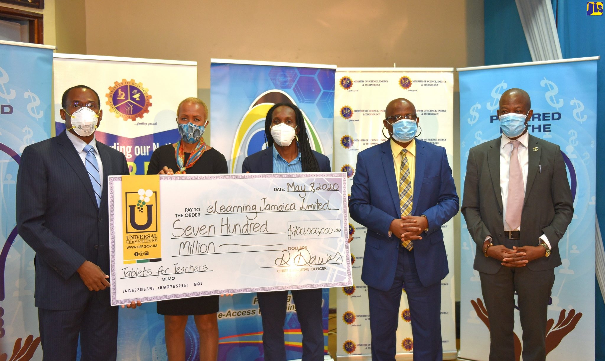 Minister of Finance and the Public Service, Dr. the Hon. Nigel Clarke (left); Minister of Science, Energy and Technology, Hon. Fayval Williams (second left); and Minister of State in the Ministry of Education, Youth and Information, Hon. Alando Terrelonge (centre), display  a symbolic cheque  for $700 million presented to e-Learning Jamaica by the Universal Service Fund (USF) for the procurement of tablet computers, under the Tablets for Teachers Programme, during a ceremony at the PCJ Auditorium, in New Kingston, on May 7. Also at the presentation are  Chief Executive Officer, e-Learning Jamaica, Keith Smith (second right) and Chief Executive Officer, Universal Service Fund (USF), Daniel Dawes.