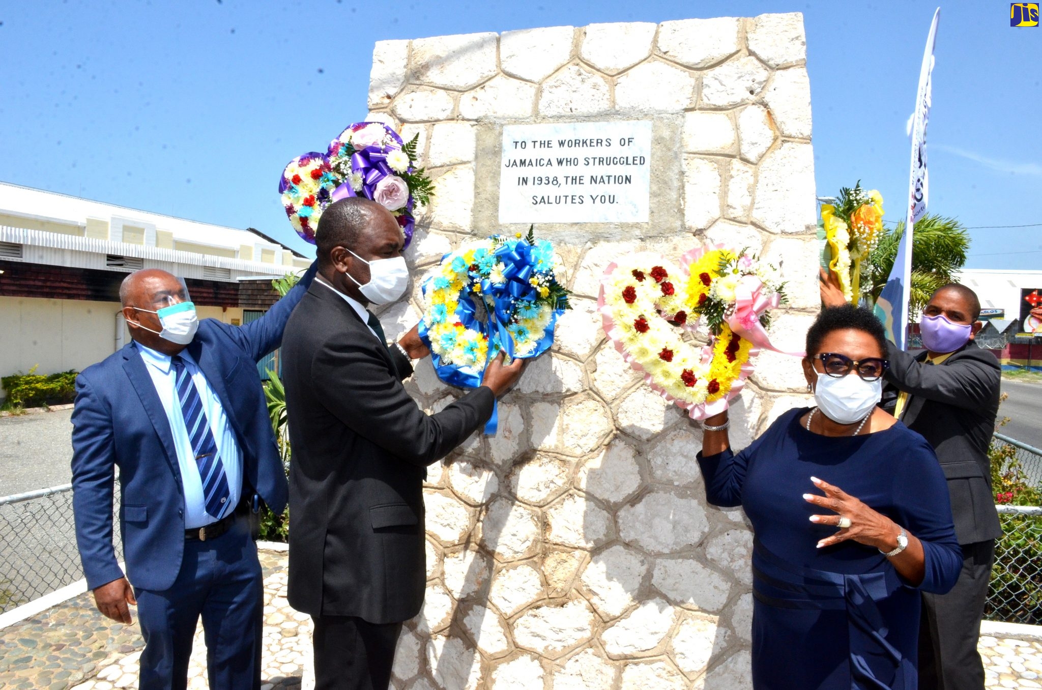 Minister of Culture, Gender, Entertainment and Sport, Hon. Olivia Grange (second right), makes remarks before placing a wreath at the Aggie Bernard Monument, Kingston Craft Market, downtown Kingston, on May 19, in recognition of  National Workers’ Week/Labour Day. Workers’ Week is being observed under the theme ‘Together we rise, together we build and together we progress’, to pay tribute to Jamaican workers who participated in the 1938 Labour Riots, which led to improved working conditions for the workers of today. Waiting to place their wreaths  (from left) are State Minister in the Ministry of Labour and Social Security, Hon. Zavia Mayne;  Mayor of Kingston, Senator Councillor Delroy Williams (right); and Deputy Mayor of Kingston, Councillor Winston Ennis.