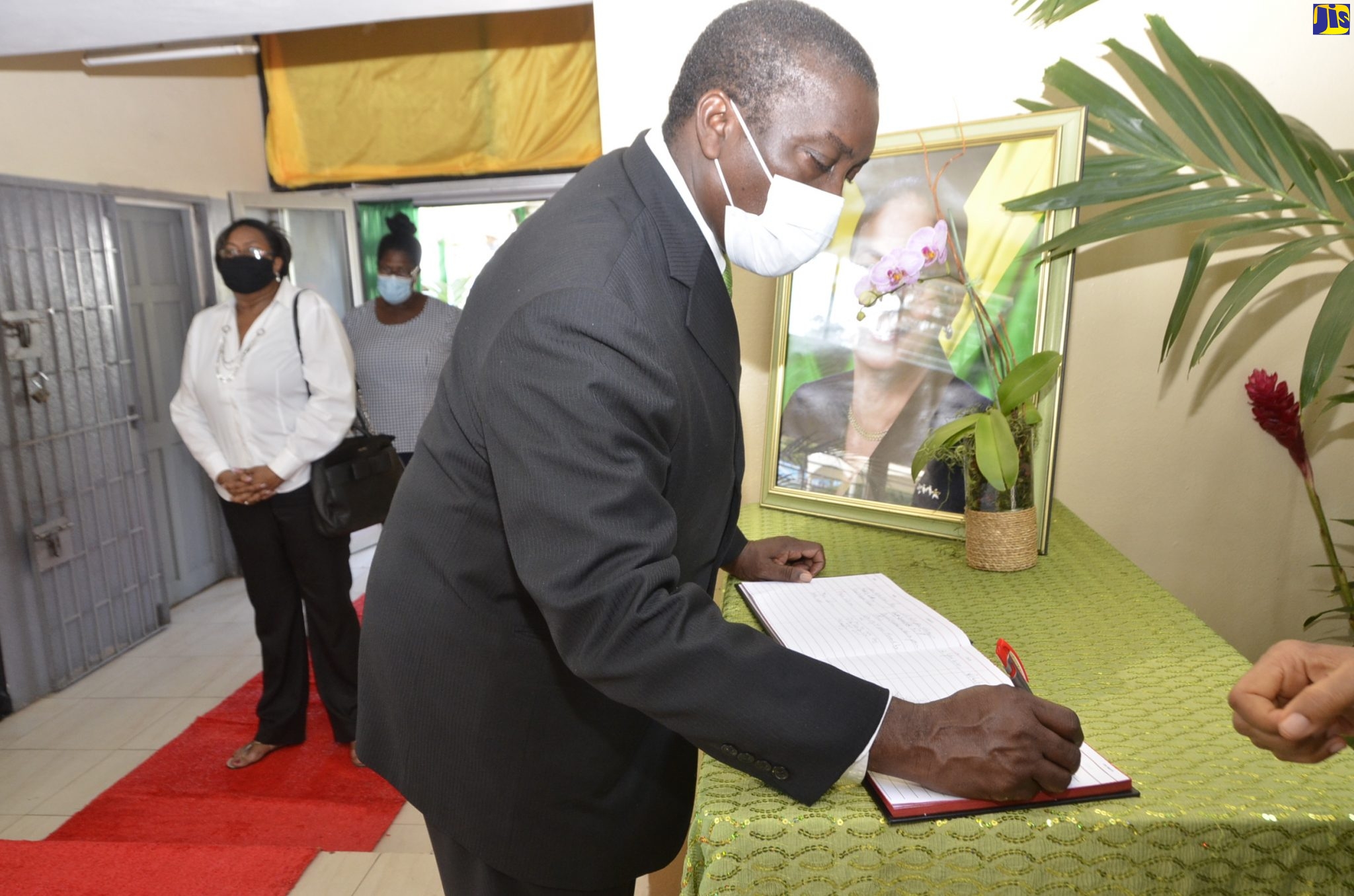 Minister of Transport and Mining, Hon. Robert Montague, signs the condolence book for the late Minister of Labour and Social Security, Hon. Shahine Robinson, at the St John’s Anglican Church Hall in Ocho Rios, St Ann during a public viewing on Friday (June 12).