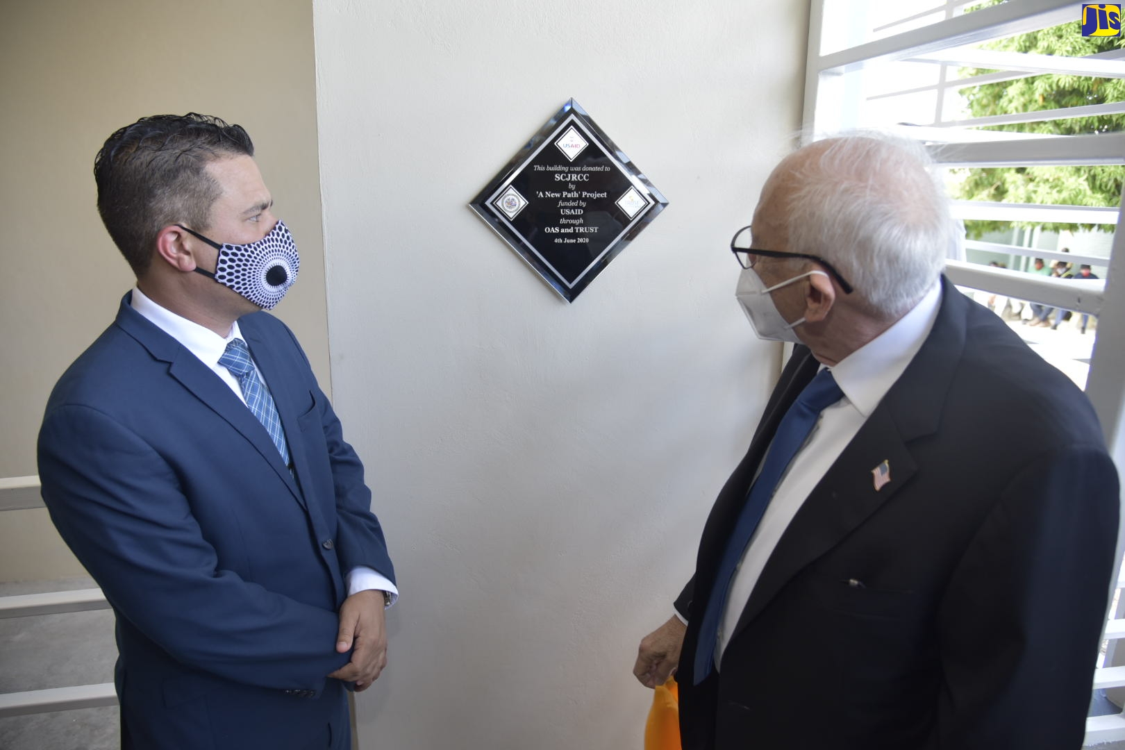 Minister without Portfolio in the Ministry of National Security, Senator the Hon. Matthew Samuda (left), and United States Ambassador to Jamaica, His Excellency Donald Tapia, view a commemorative plaque mounted inside the new multipurpose classroom at the South Camp Juvenile Correctional Centre in Kingston. The facility was formally opened on Thursday (June 4).