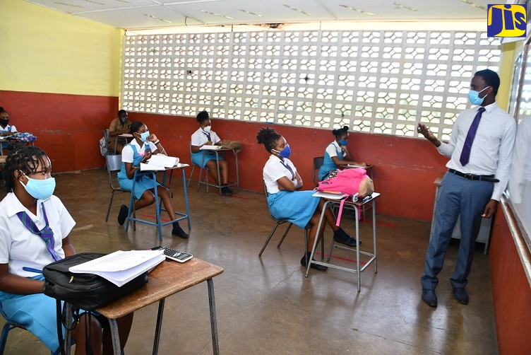 (FILE) Grade-11 Maths Teacher at the William Knibb Memorial High School in Trelawny, Ronald Beckford (right), holds revision classes with students on Monday (June 8).