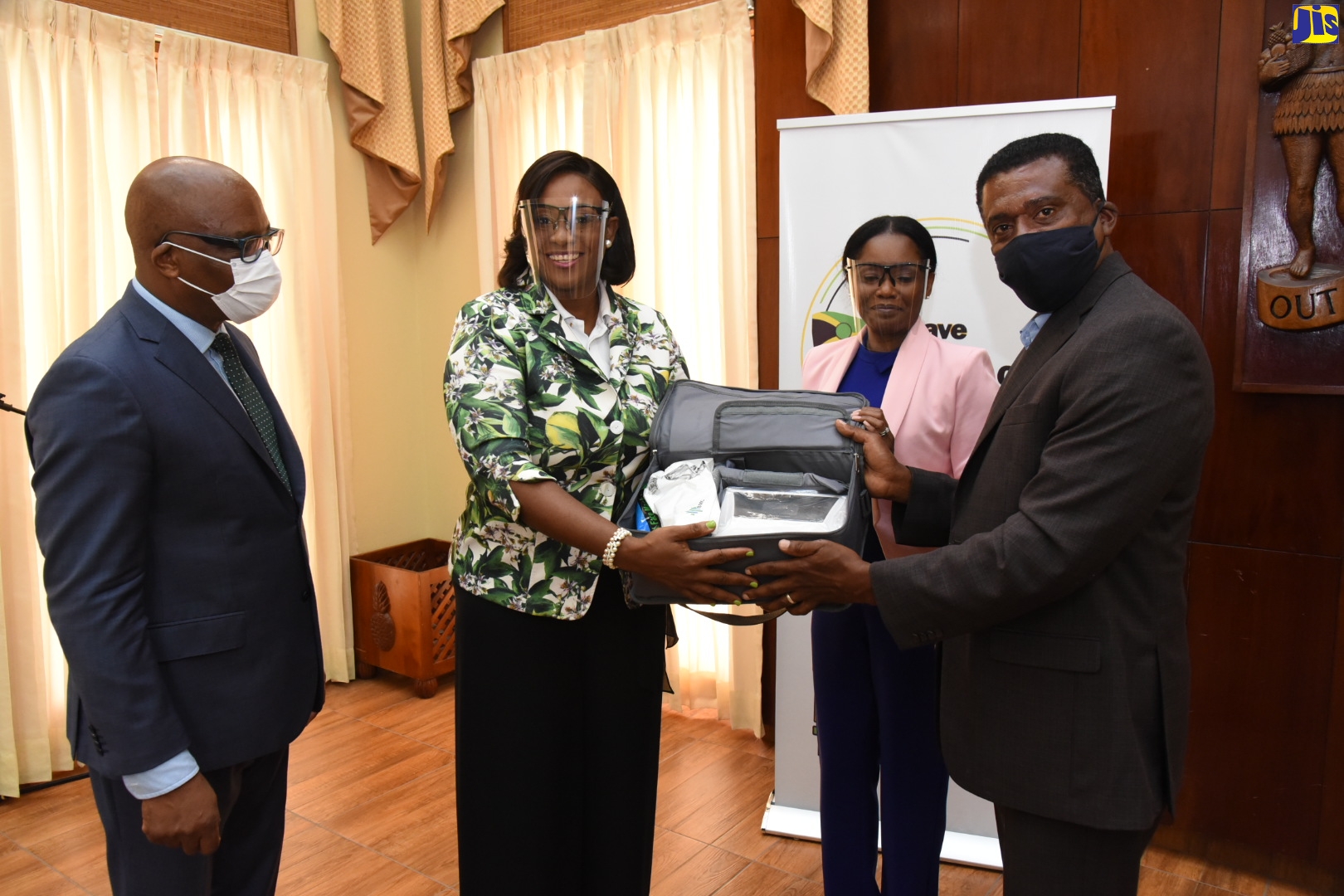 Wife of the Prime Minister and patron of the Save Our Boys and Girls Foundation, the Most Hon. Juliet Holness (second left), hands over a ventilator to Executive Director, the Health for Life and Wellness Foundation in the Ministry of Health and Wellness, Courtney Cephas (right).  Looking on are Antoinette Taddeo and Minister without Portfolio in the Ministry of Economic Growth and Job Creation, Hon. Leslie Campbell. Five ventilators, donated by local businessman and developer, Leo Taddeo and his wife, Antoinette, were presented during a ceremony at Jamaica House on Tuesday (June 23).