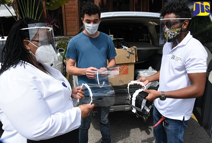 Regional Director, South East Regional Health Authority (SERHA), Dr. Sandra Chambers (left), examines one of the face shields donated by Citizens Response Jamaica. The entity handed over 1,000 face shields to SERHA at a ceremony held on June 16 at Blue Dot Insights, in Kingston. Sharing the moment are members of Citizens Response Jamaica, Kriston Kong (centre) and Shane Smith. Citizens Response Jamaica was born out of a shared goal of contributing to the fight against the COVID-19 pandemic.