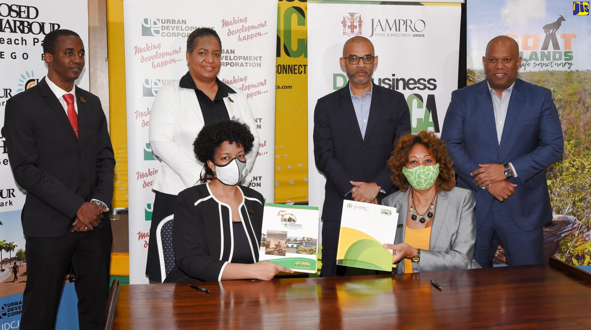 Urban Development Corporation (UDC) General Manager, Heather Pinnock (left, seated), and President of Jamaica Promotions Corporation (JAMPRO), Diane Edwards (right, seated), display copies of the signed memorandum of understanding (MOU) between the entities that will facilitate their collaboration on programmes and initiatives, aimed at leveraging the UDC’s assets and engagements to generate local and international investments, and create business development opportunities in Jamaica. The signing took place at JAMPRO’s Corporate Office in New Kingston, on Wednesday (June 17). Also attending were (from left) UDC Deputy General Manager, Finance, Treasury and Investment, Omar Gray; Deputy General Manager, Subsidiary Management, UDC, Lisa Golding; and JAMPRO Vice Presidents for Marketing, Gabriel Heron, and Sales and Promotions, Norman Naar.